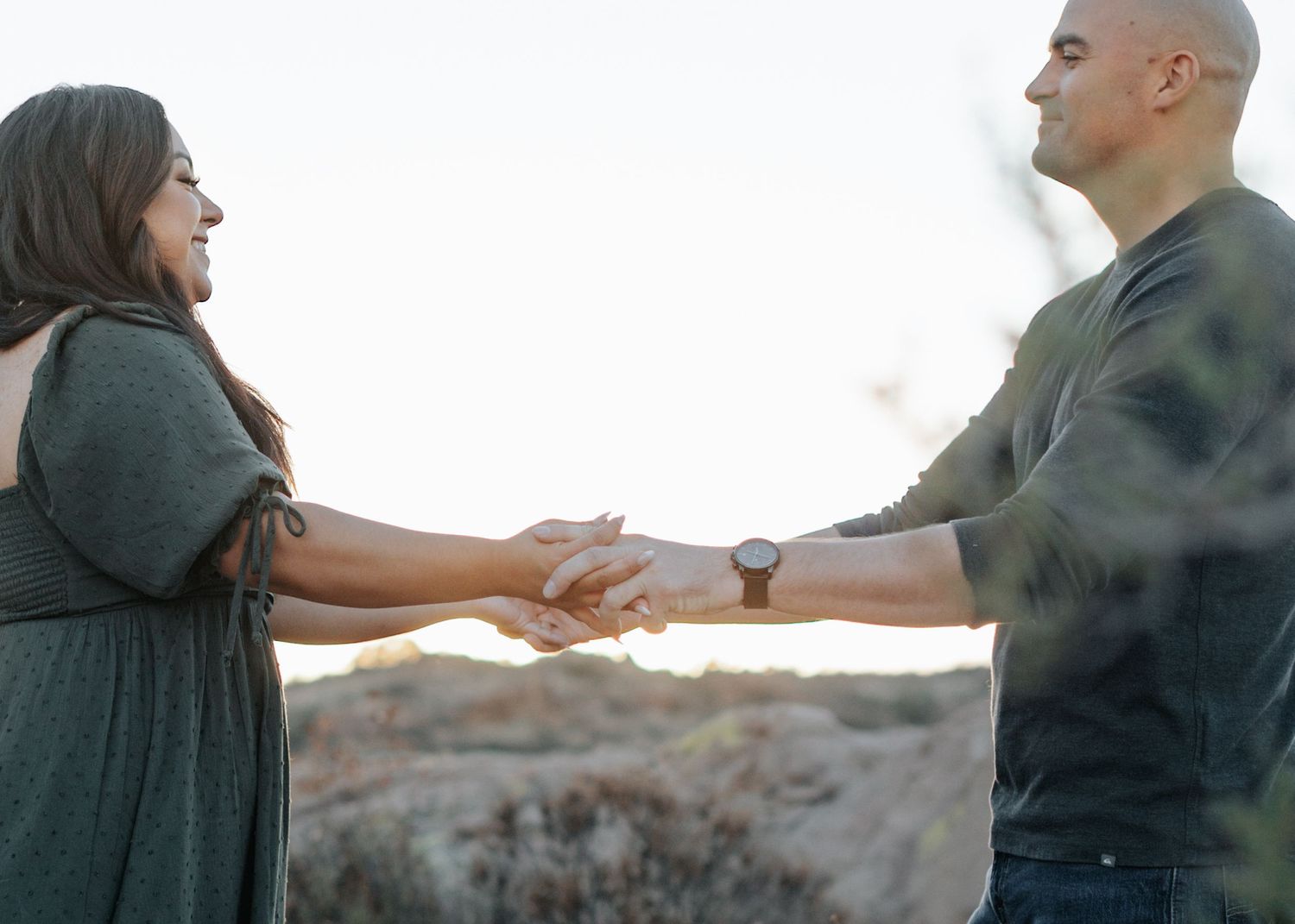 Candid moments of couple interacting in natural desert setting.