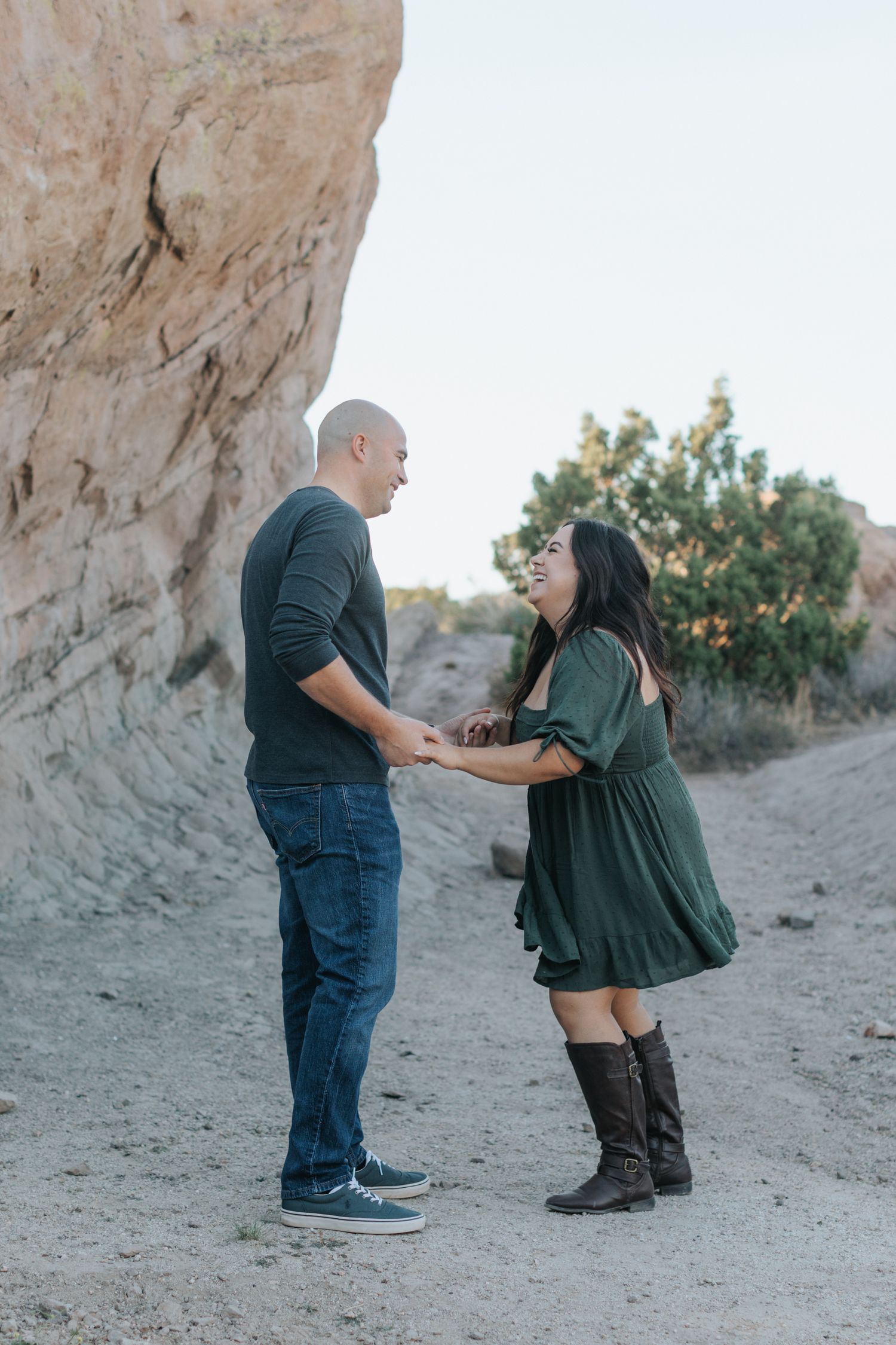 A couple shares playful moments during their desert engagement photoshoot.