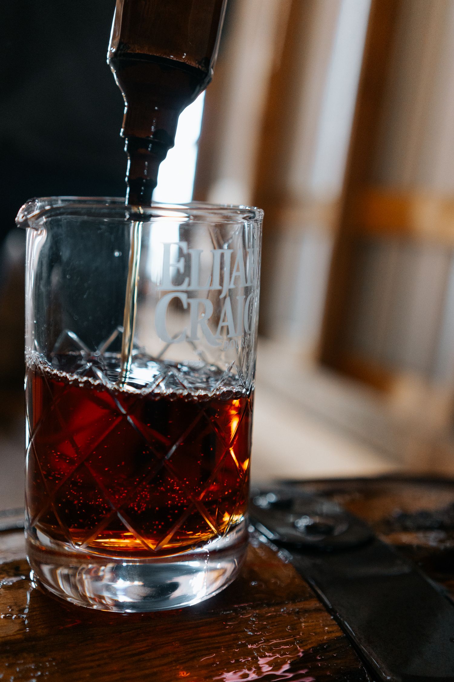 Amber bourbon being poured into a crystal glass.