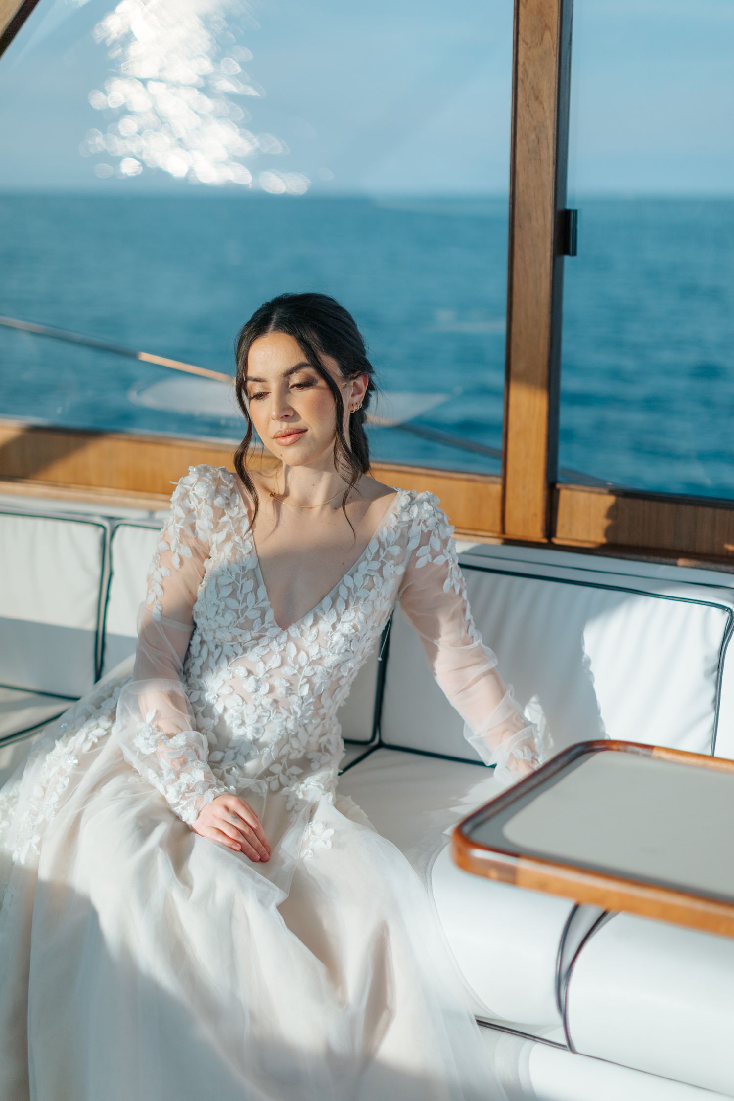 Elegant bridal photography session aboard luxury yacht with ocean backdrop.