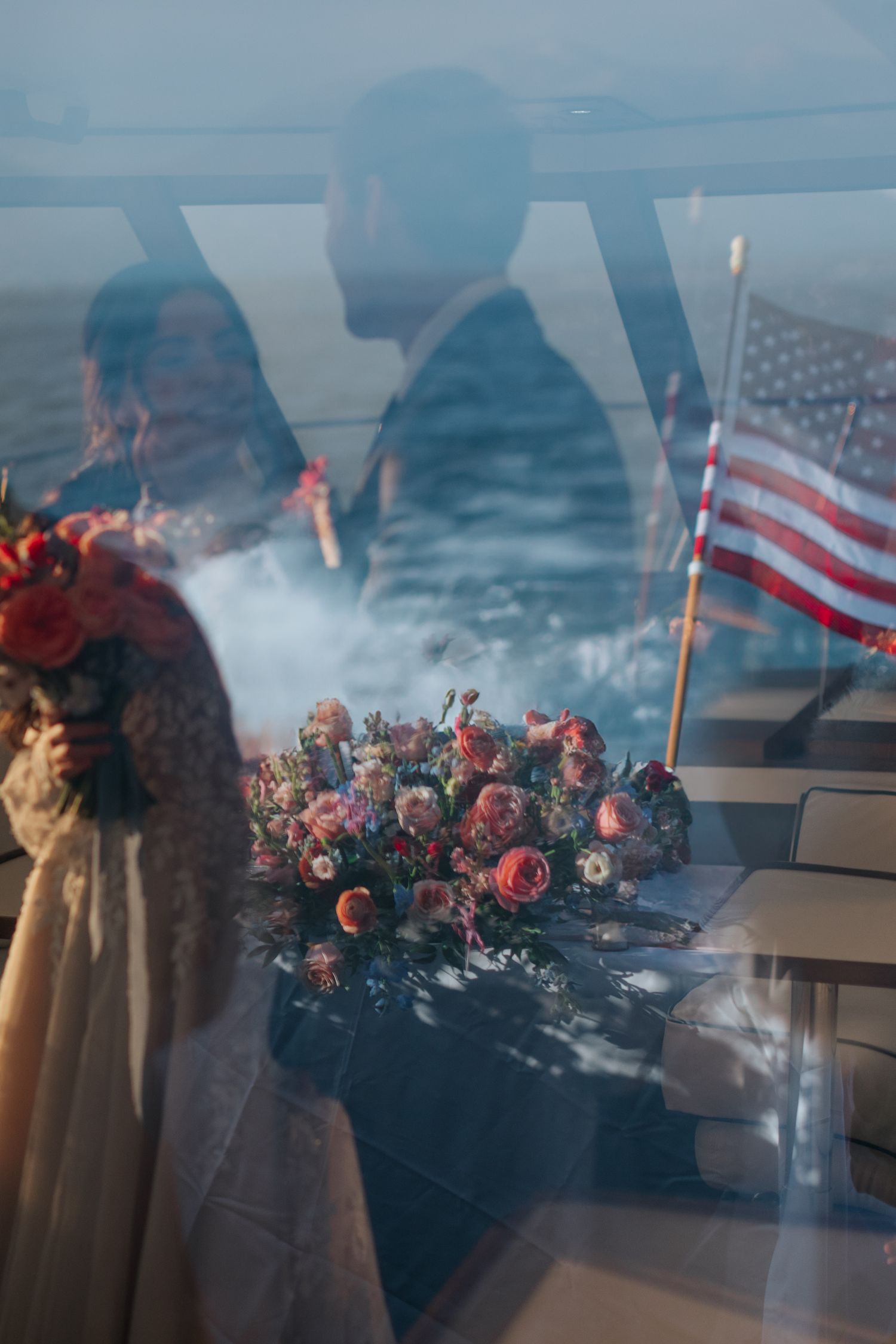 Double exposure wedding photo with American flag and floral bouquet on boat deck.
