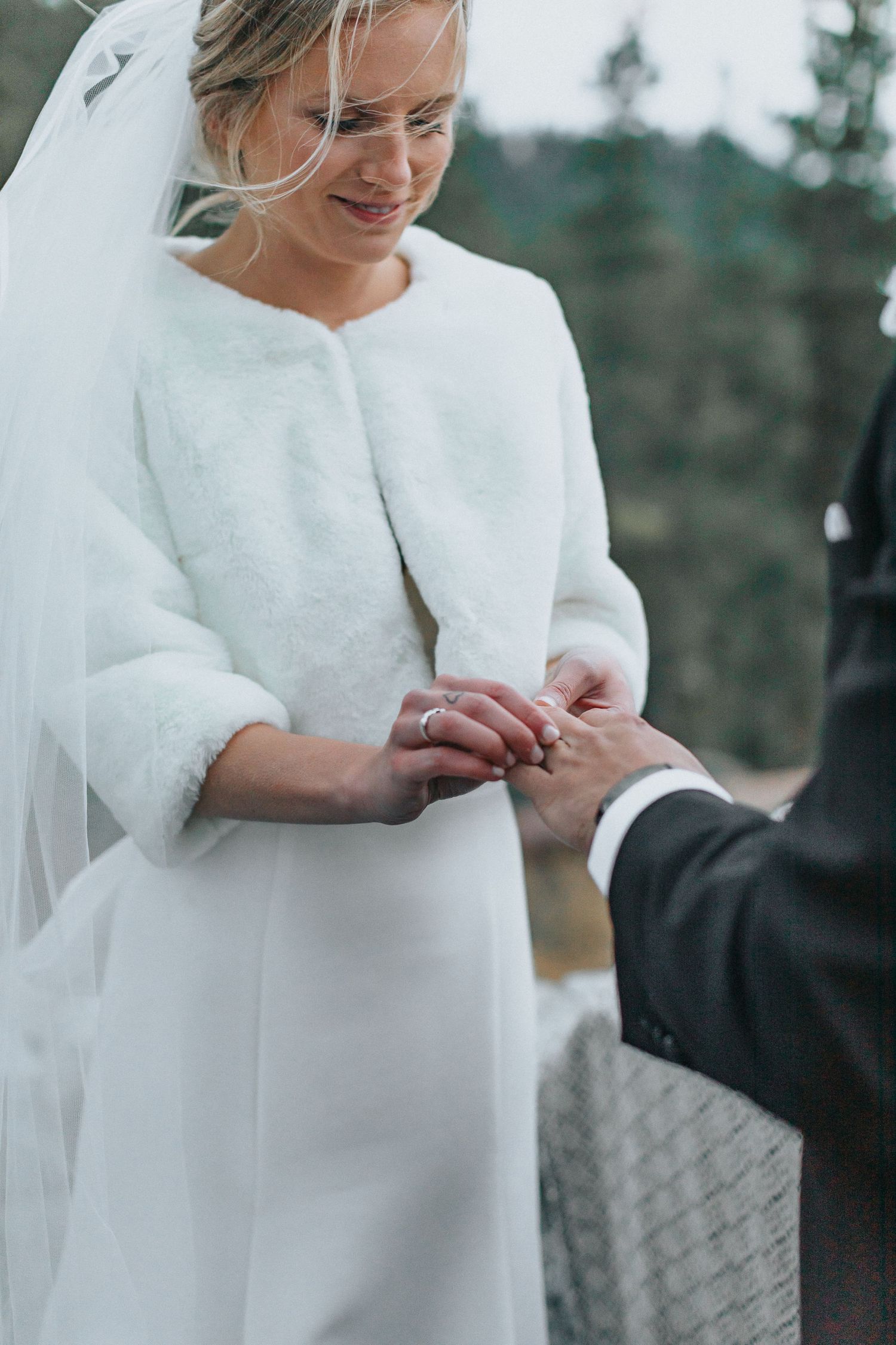 Close-up of wedding ring exchange during mountain ceremony.