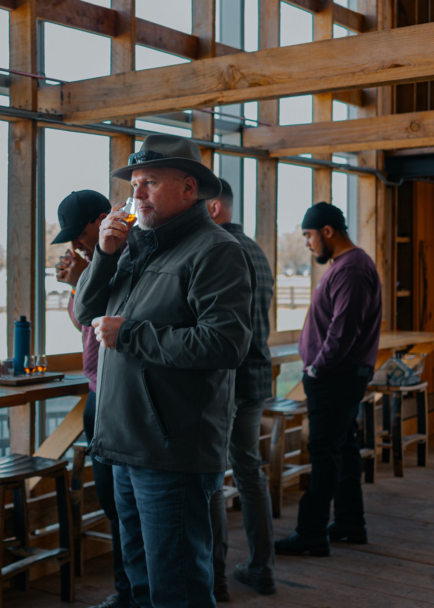 Group tasting bourbon samples in a distillery tasting room.