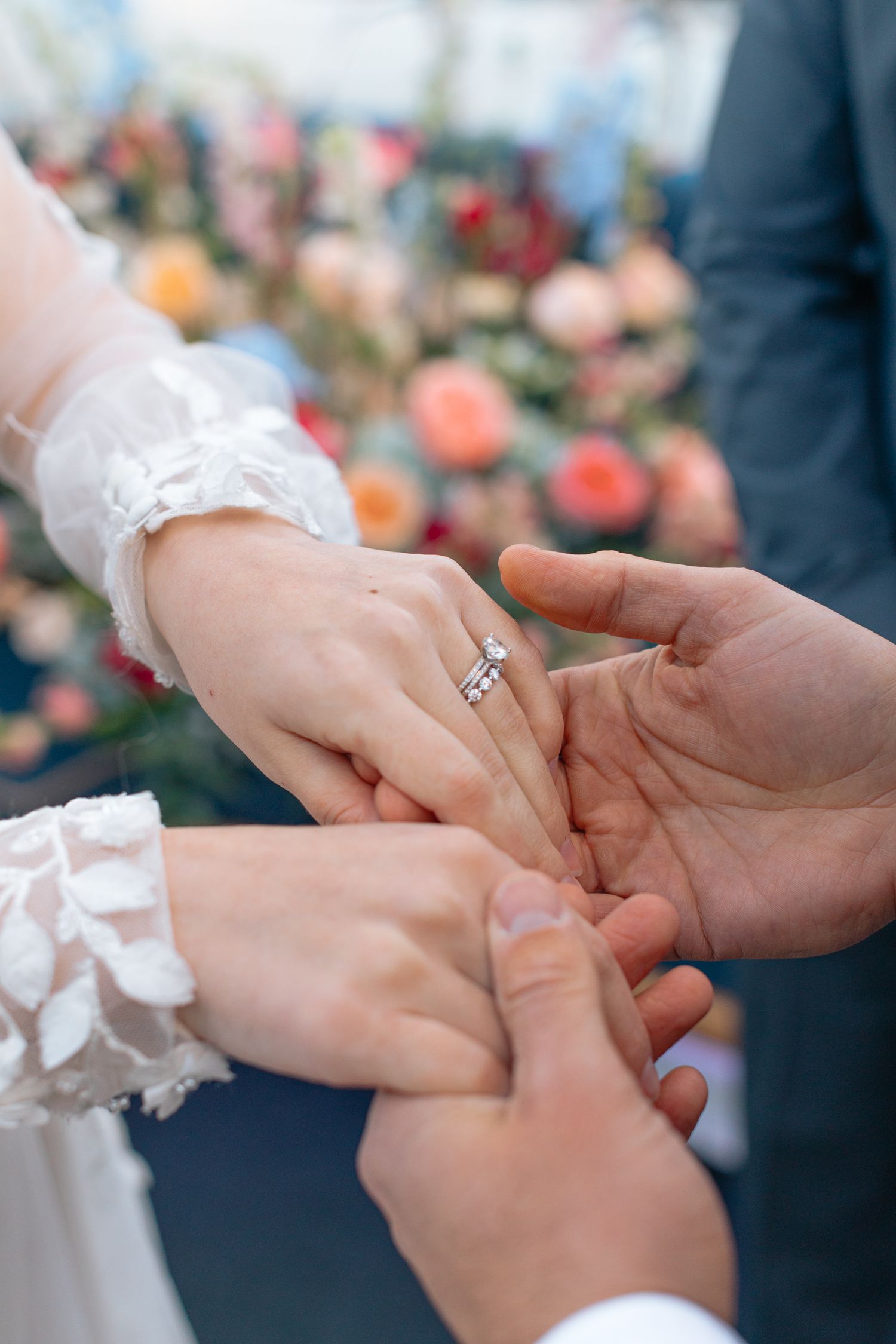 Close-up of hands exchanging wedding rings during a ceremony.