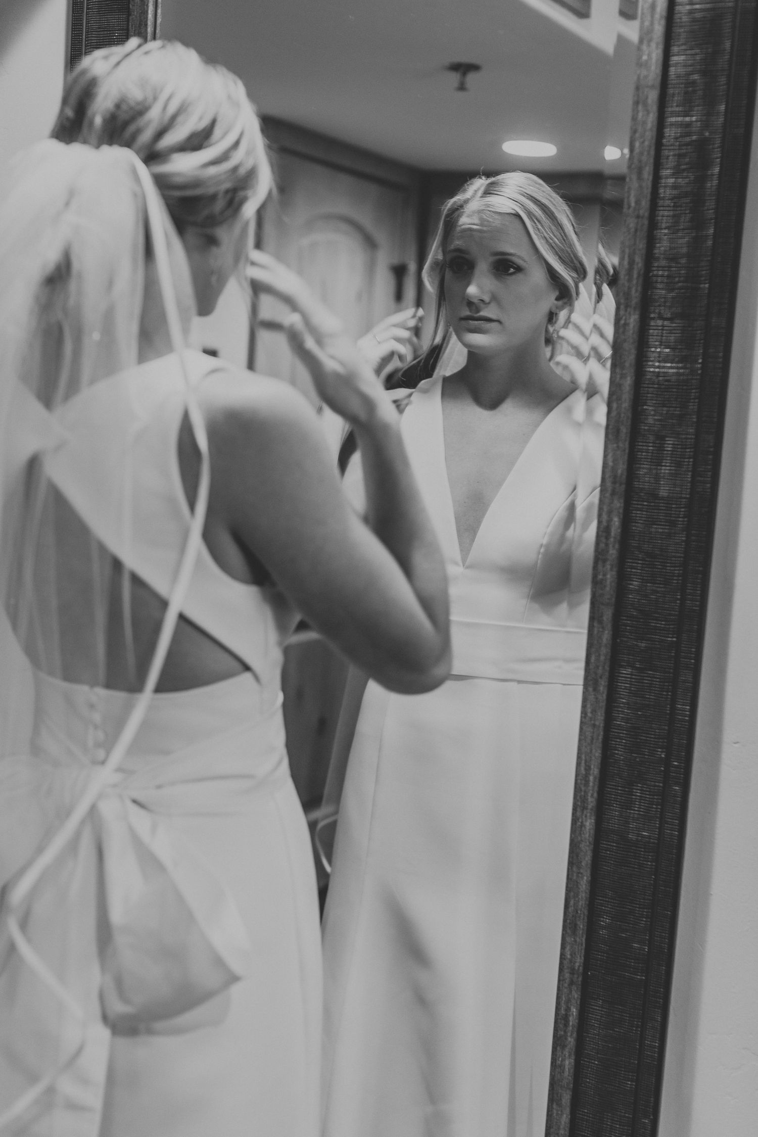 Reflection in mirror showing formal white attire preparations.