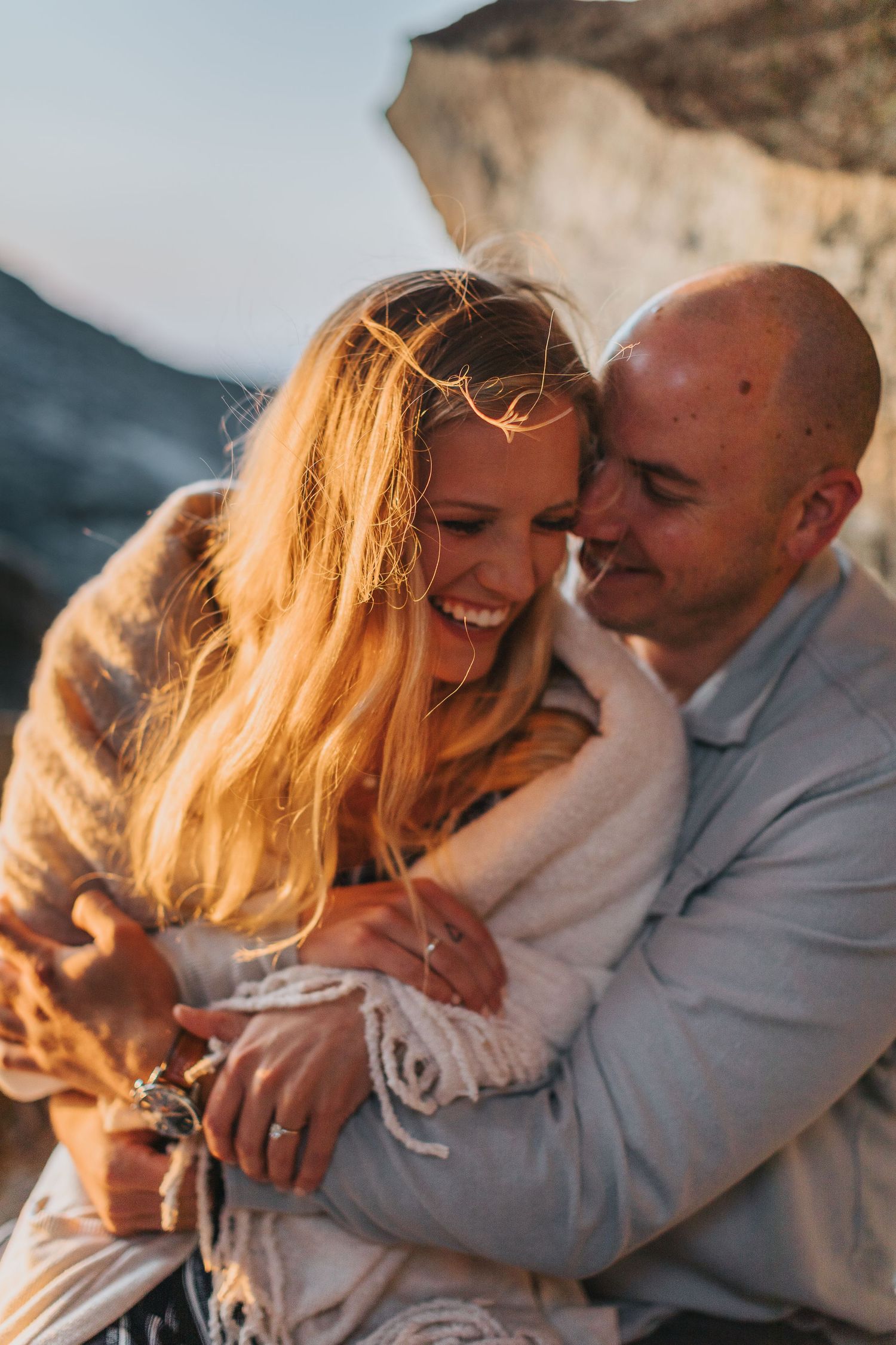 Candid moments of couple laughing and embracing in golden sunset light.