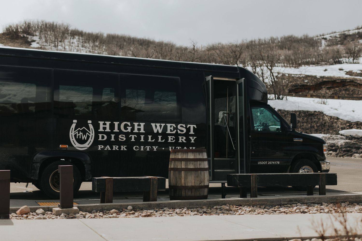 Black delivery trucks with High West Distillery branding parked in snowy conditions.