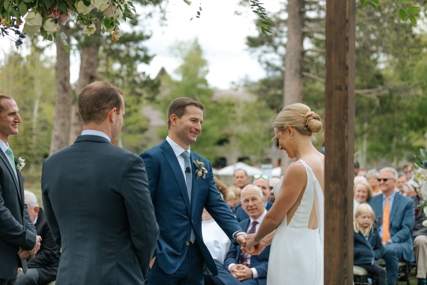 Outdoor wedding ceremony taking place in a scenic mountain forest setting.
