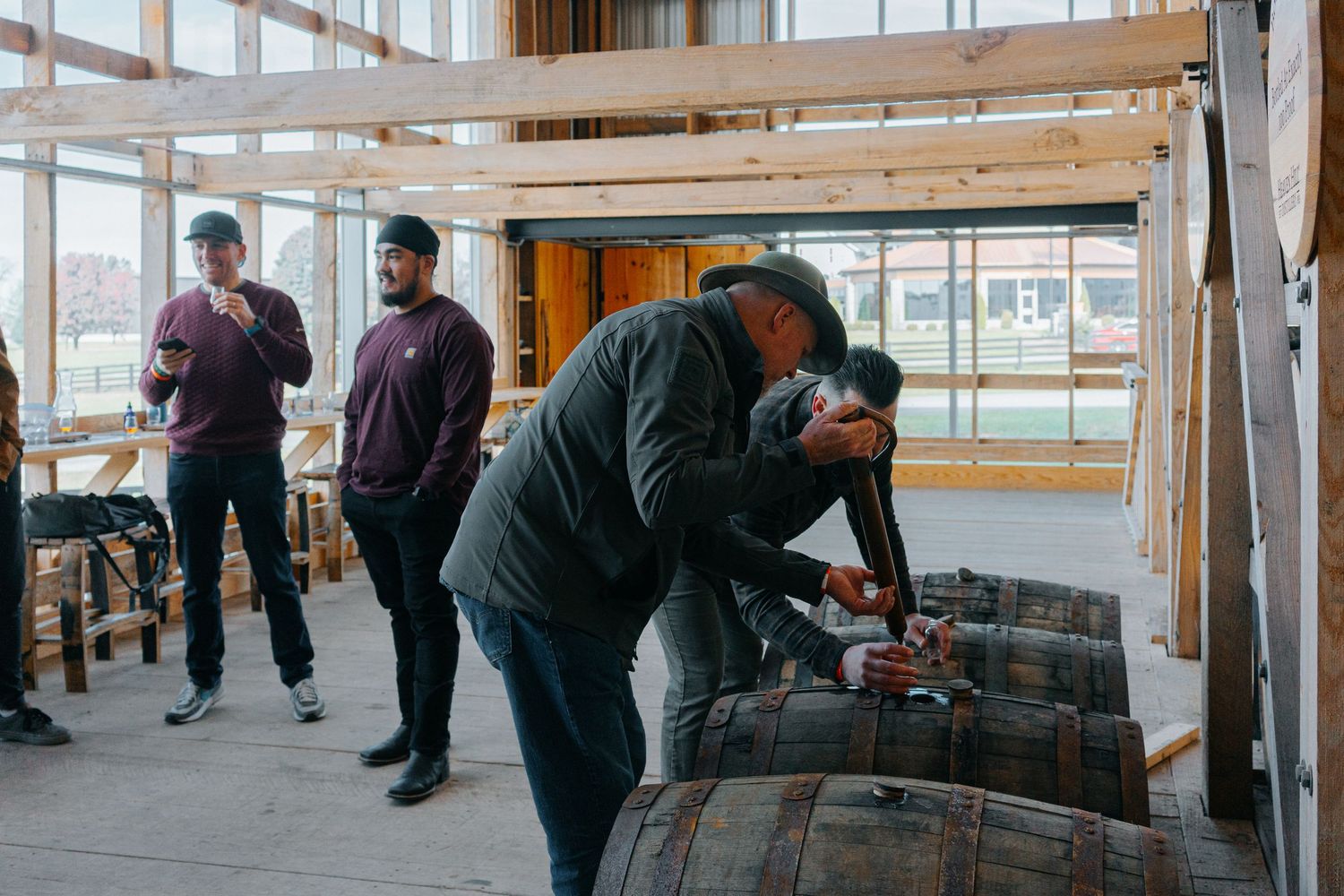 Visitors sampling bourbon at a distillery tasting counter.