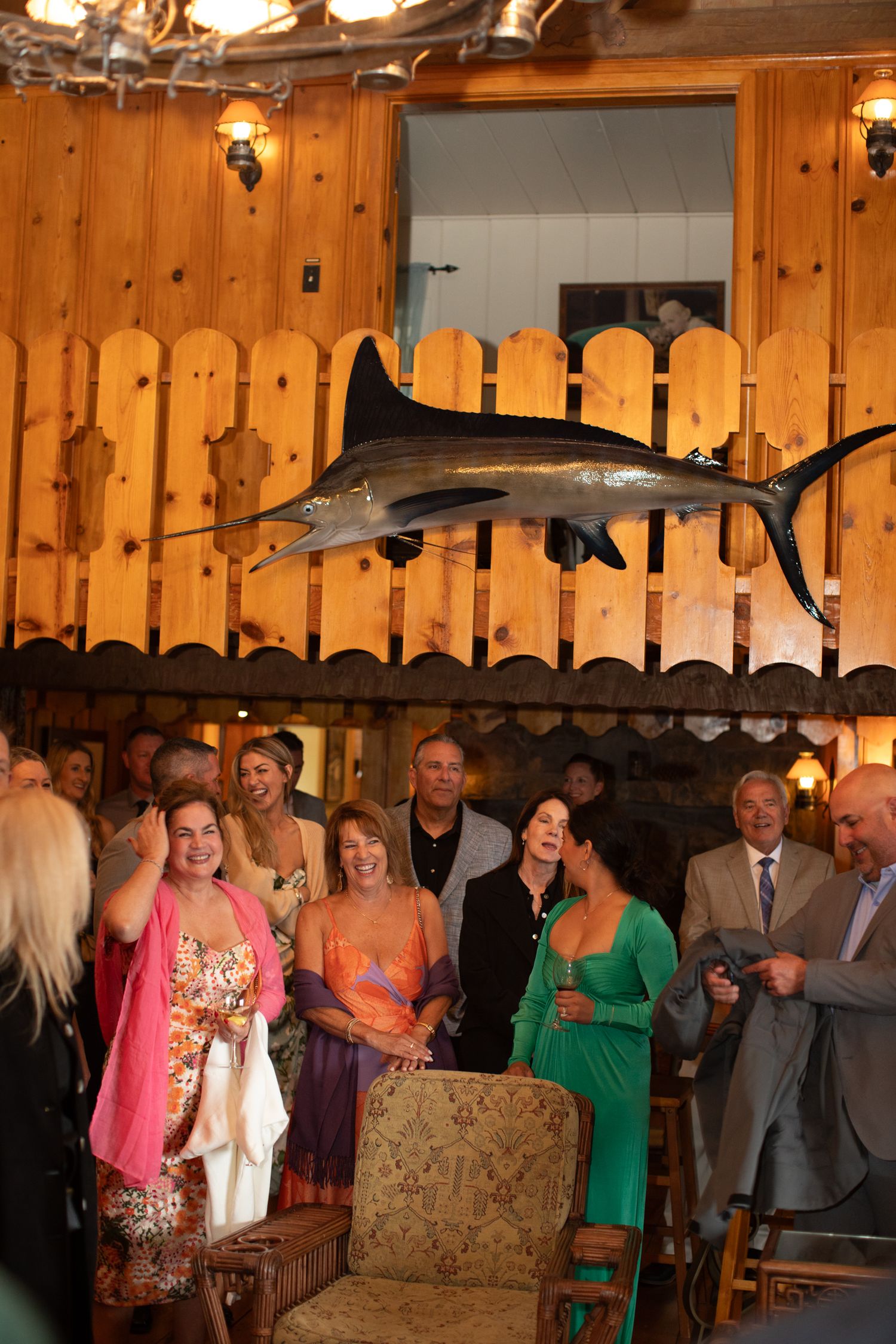 Wedding guests celebrating in a rustic wooden venue with warm lighting.