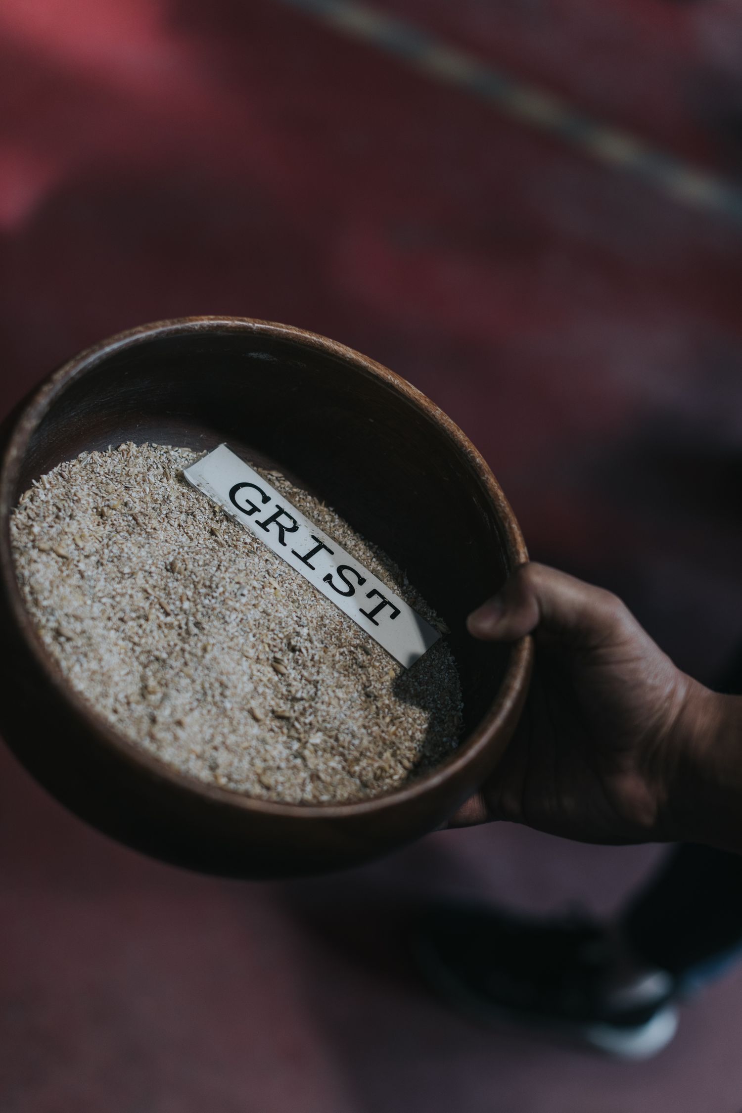 Close-up shot of grain samples in wooden measuring bowls with labels.