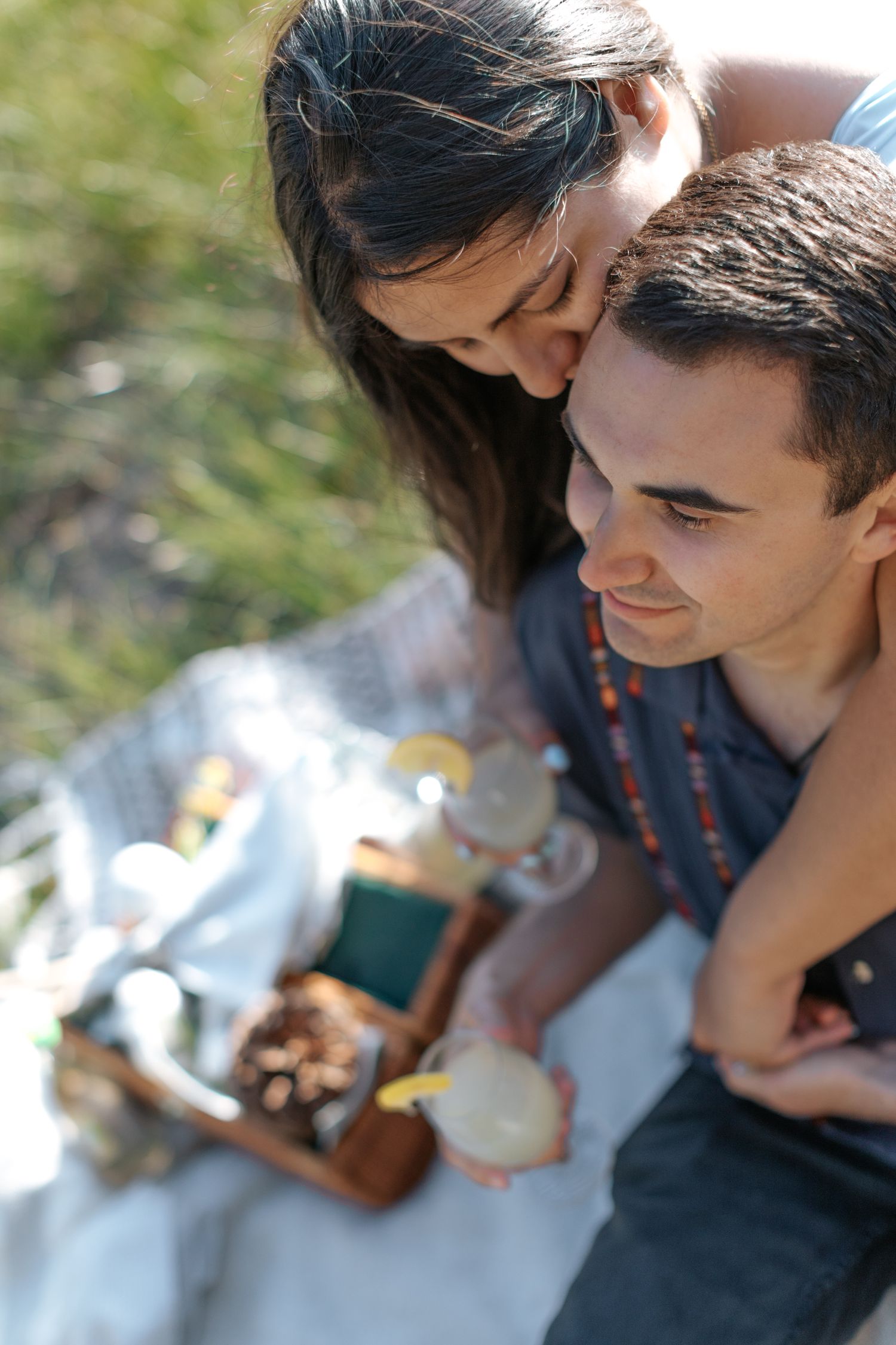 Close-up shot of couple sharing intimate moment during outdoor picnic.