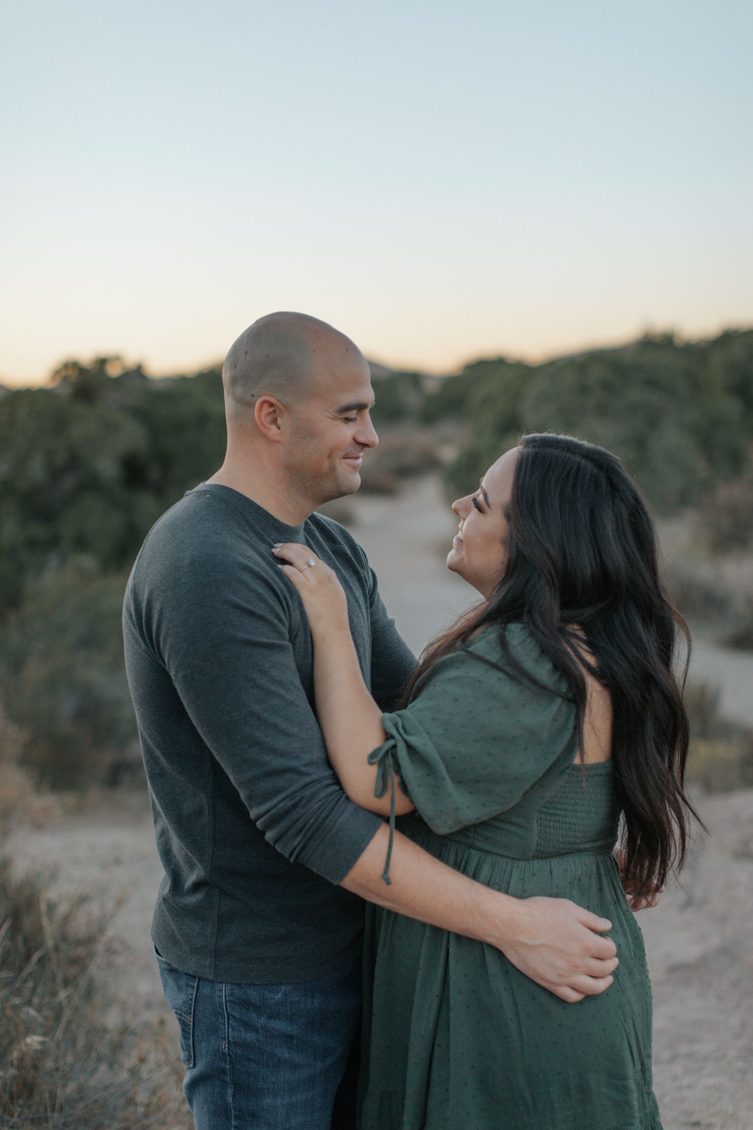 A couple embraces while enjoying sunset among desert rock formations.