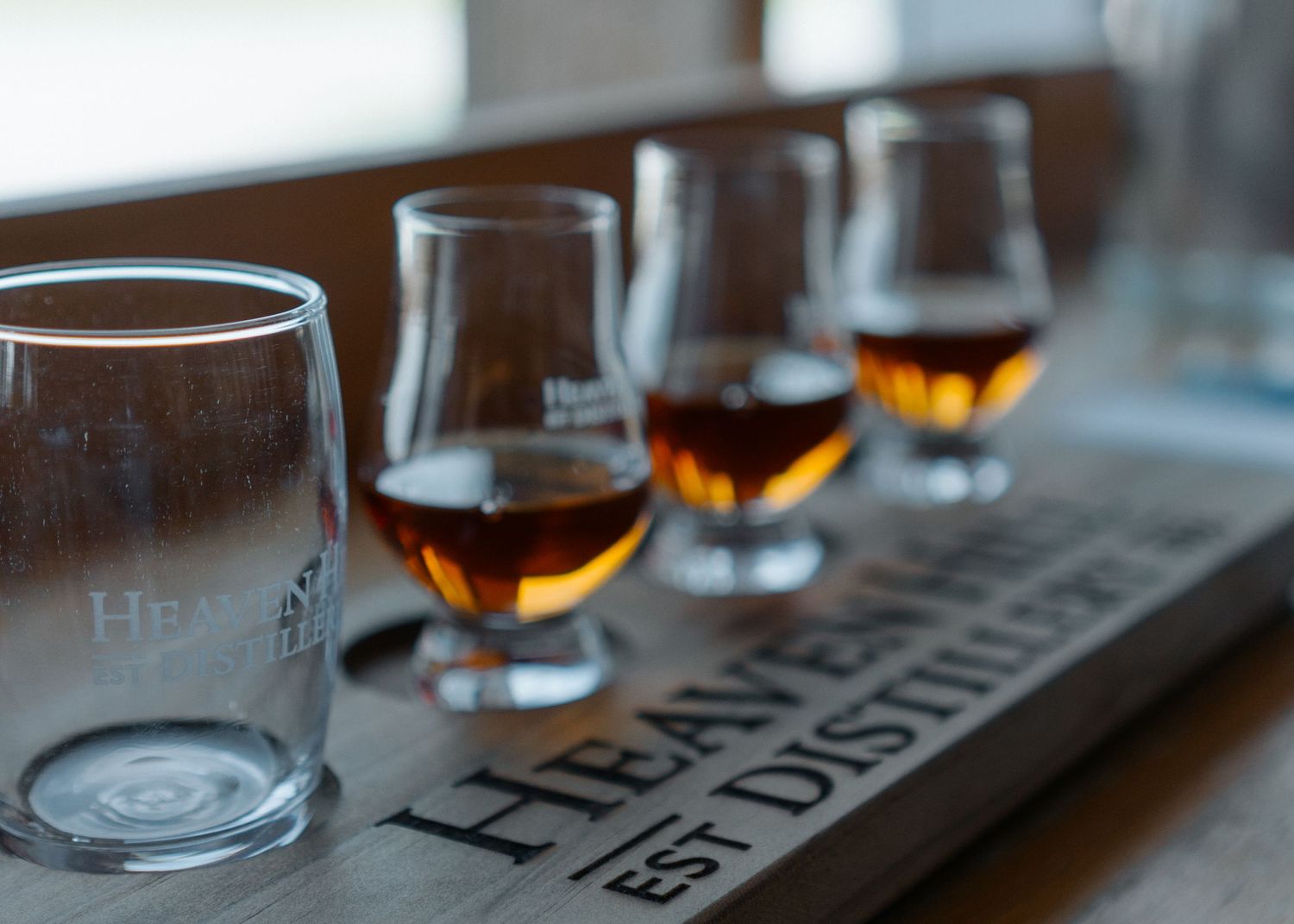 Row of whiskey tasting glasses on a table with Heaven Hill branding.