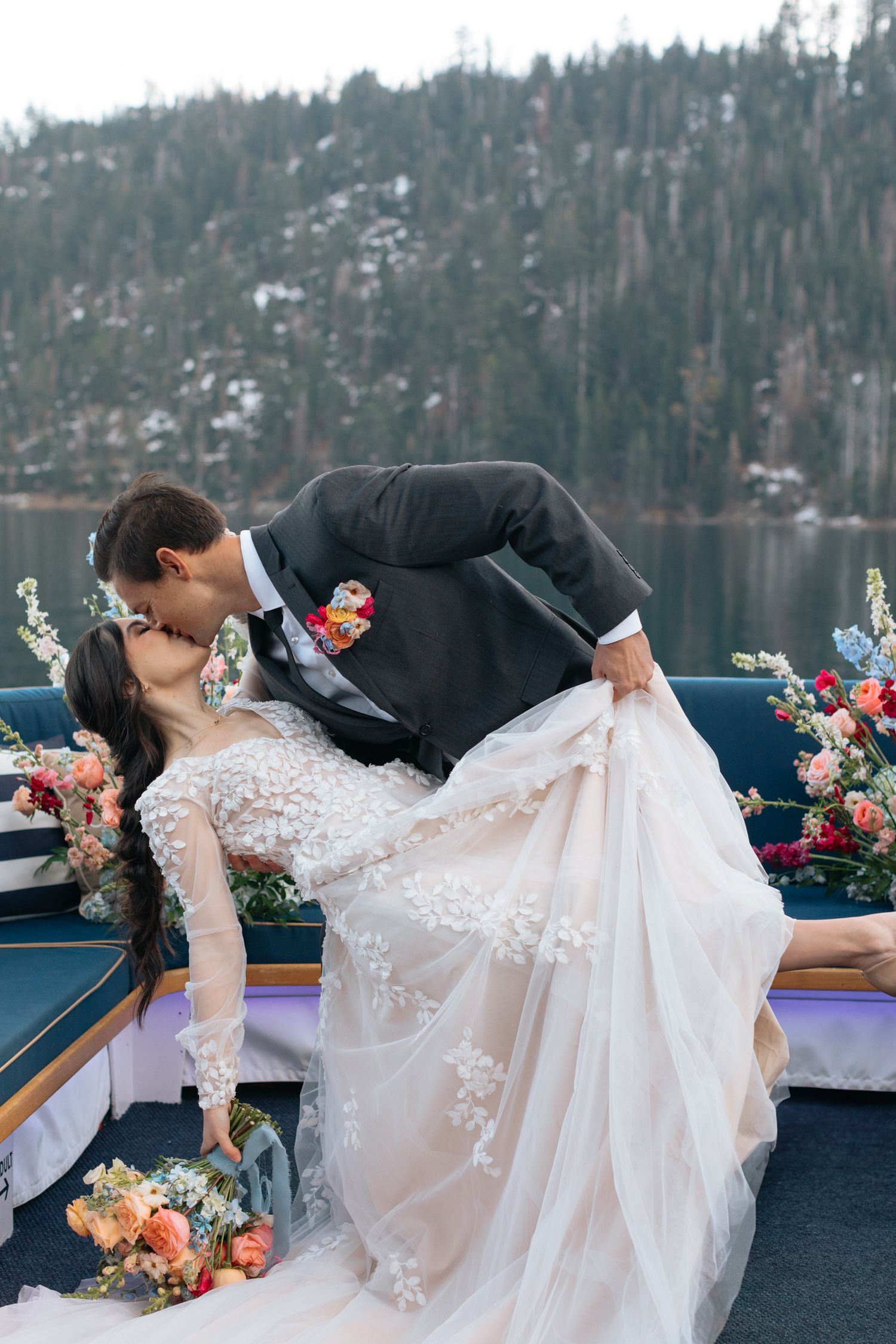 Romantic dance poses on a boat with scenic mountain lake backdrop.
