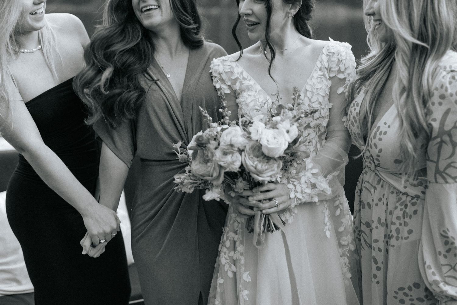 Black and white photo of wedding party laughing together.