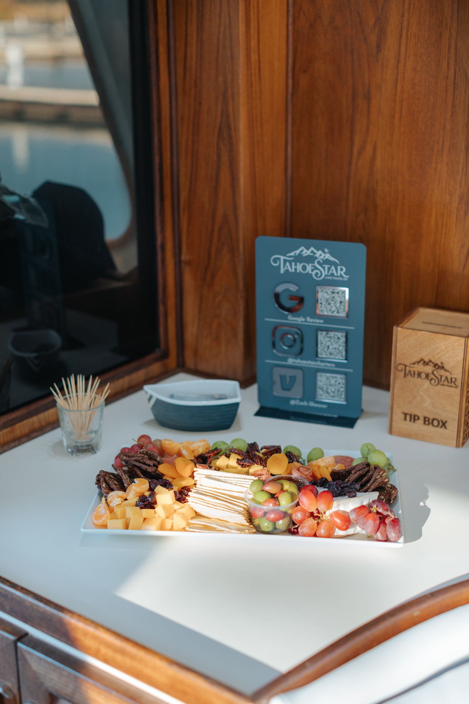 Wedding reception setup with charcuterie board and wooden signage on yacht counter.