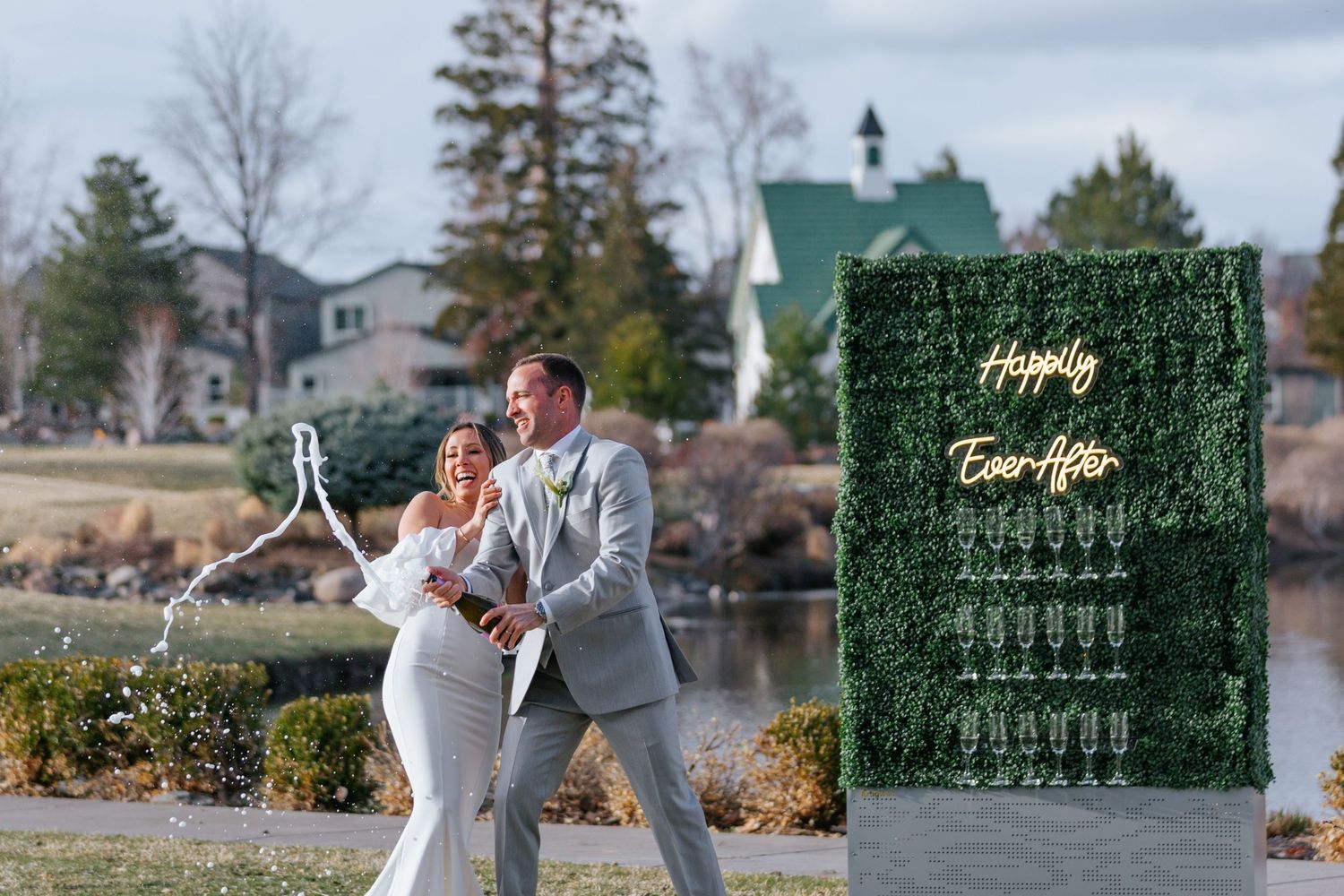 Wedding celebration setup with decorative green wall and outdoor reception details.