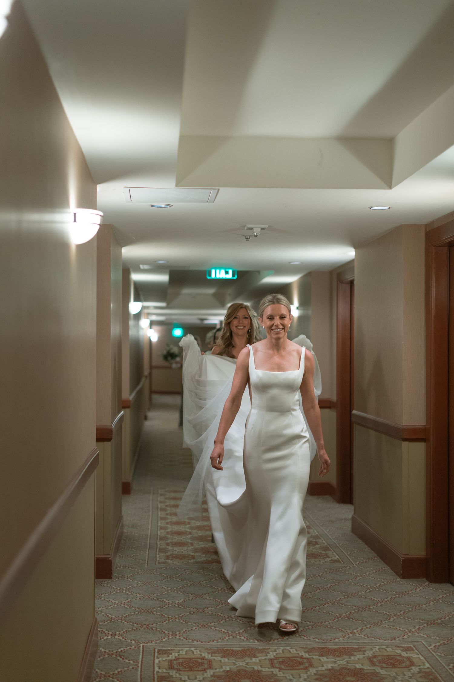 Walking sequence through a hotel hallway in an elegant white wedding gown.