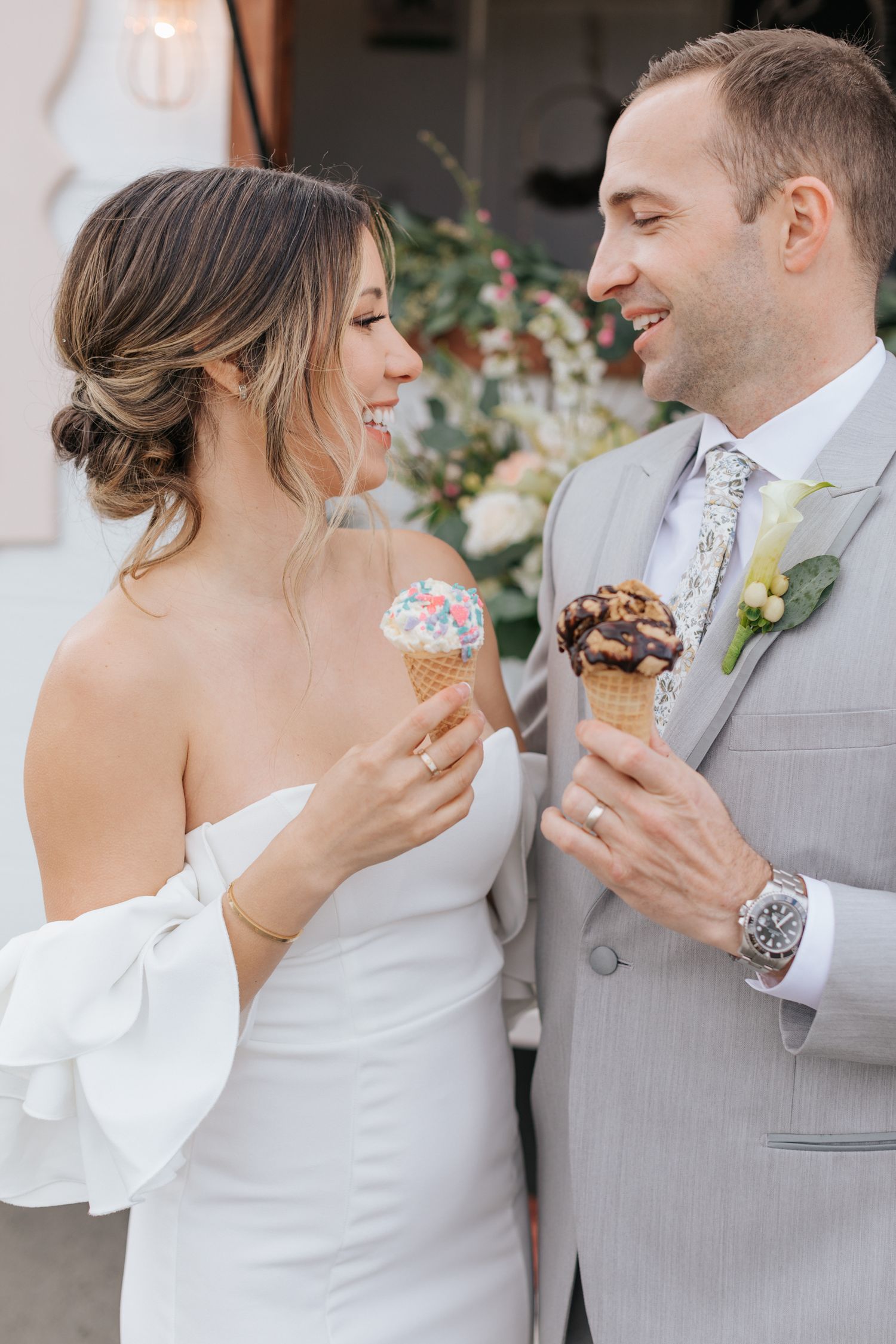 Couple sharing ice cream cones during wedding photoshoot.
