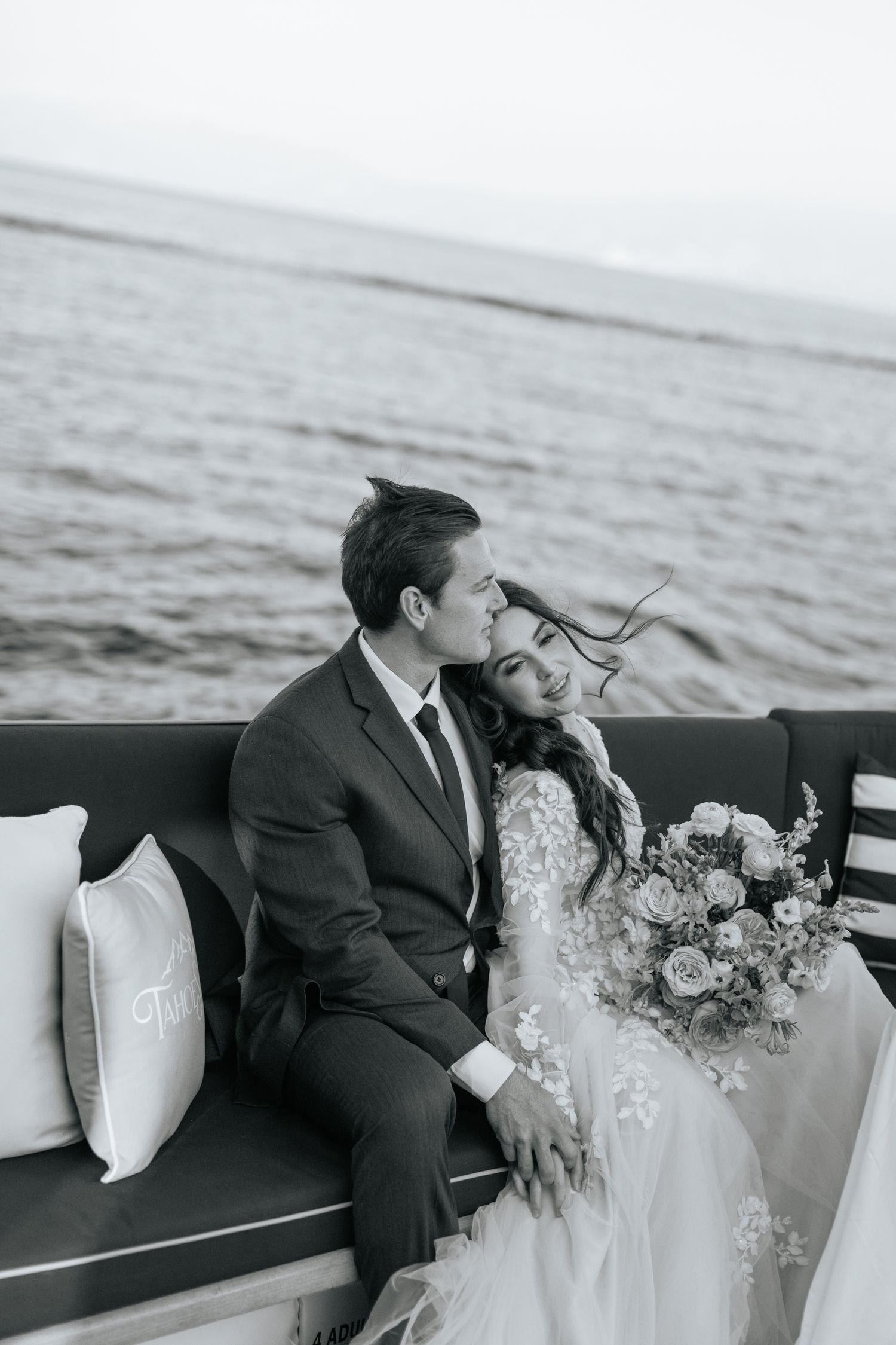 Black and white romantic moment on boat with ocean backdrop.