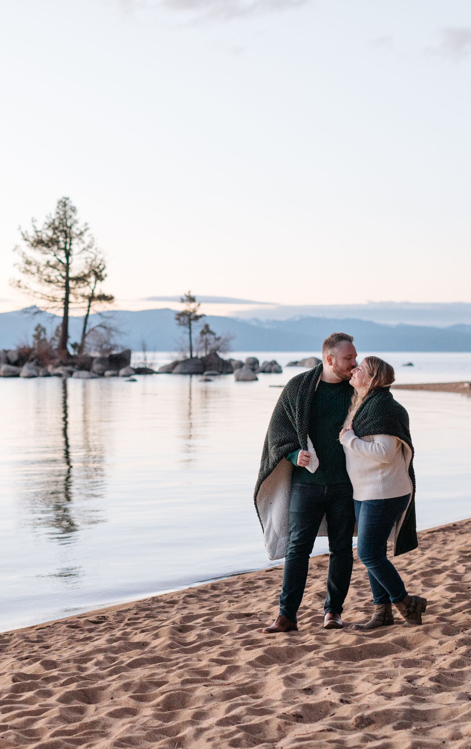 Romantic beach proposal sequence with mountains and lake in background.