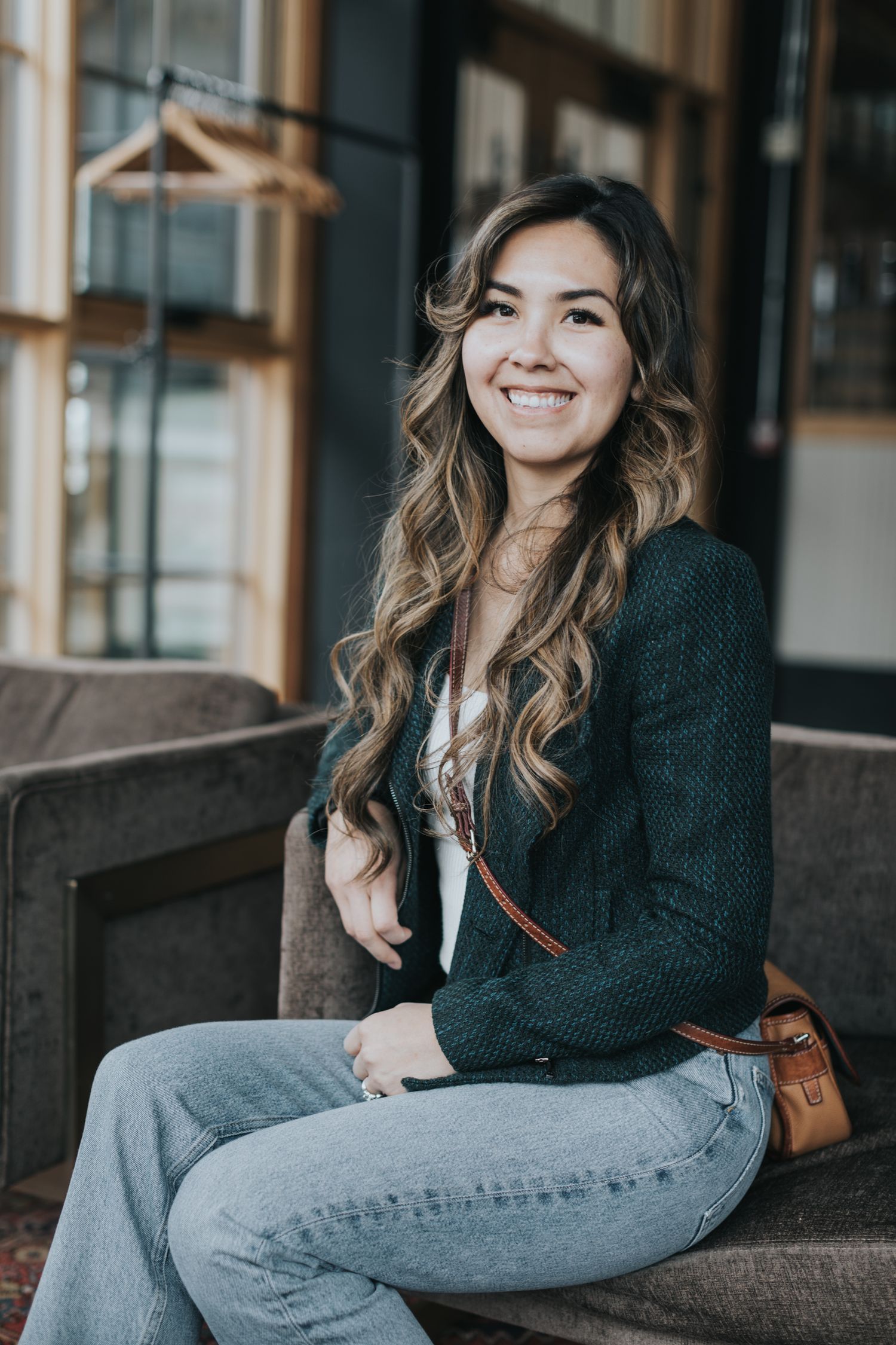 Casual portrait session on grey couch in modern industrial space.