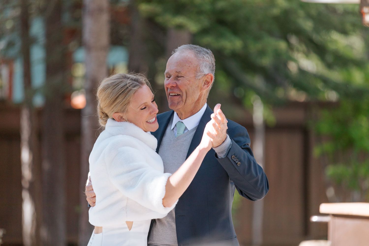 Couple sharing a romantic dance moment at an outdoor wedding reception.