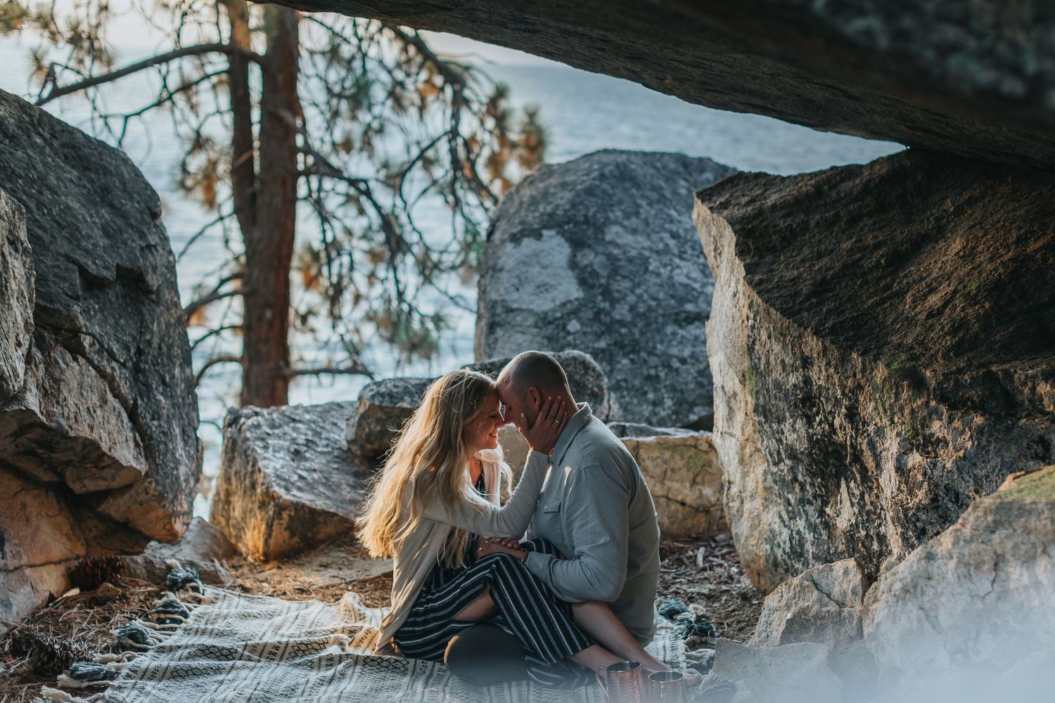 Romantic couple spending time together under a rocky overhang near the water.