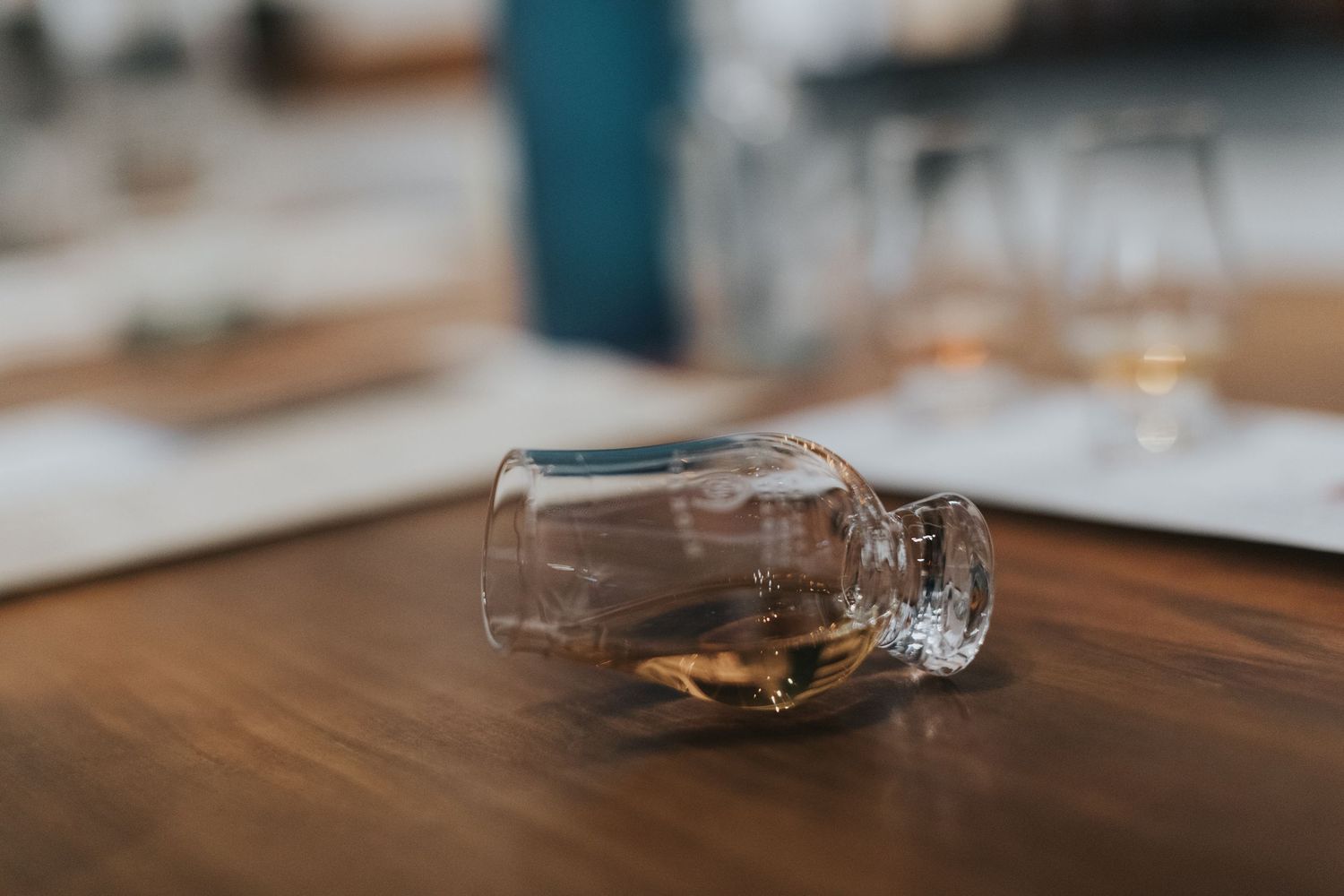 Close-up of whiskey glasses arranged for tasting on dark wooden surface.