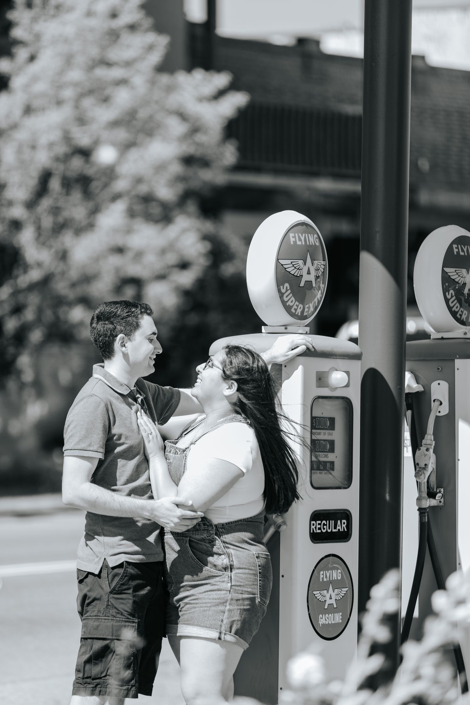 Black and white image of people interacting near vintage-style pay phones.