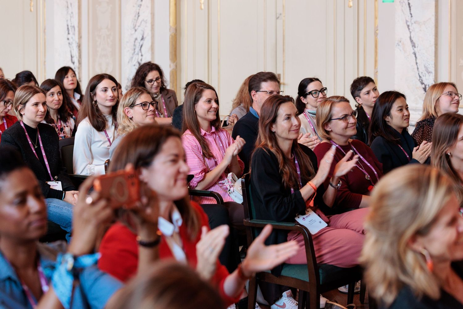 Group of visitors seated and clapping at the Collective Gathering event in Bern