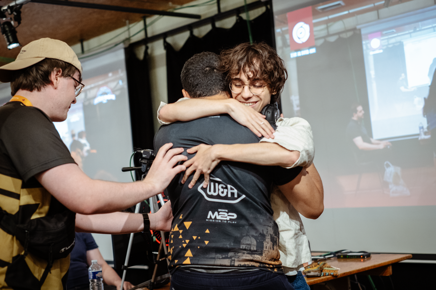 Drybie embraces Youssef on stage after their victory at the Swiss Dome Super Smash Bros. tournament.