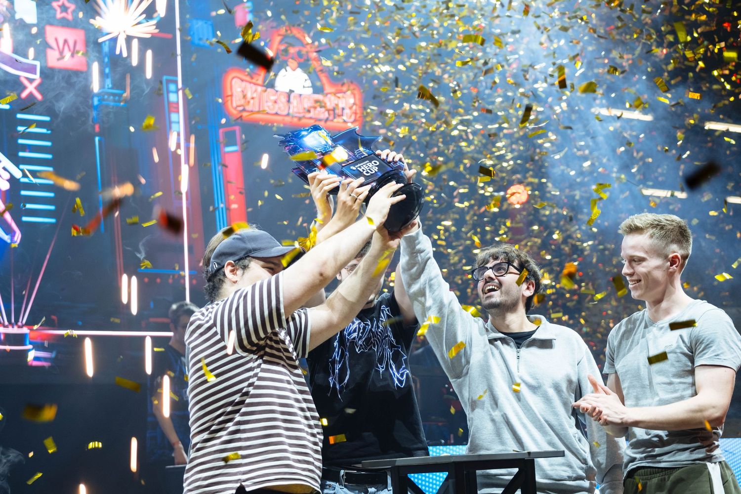 Swiss Agents celebrate their 2–0 League of Legends Swisscom Hero Cup Finals win, holding the trophy on stage as confetti falls around them.