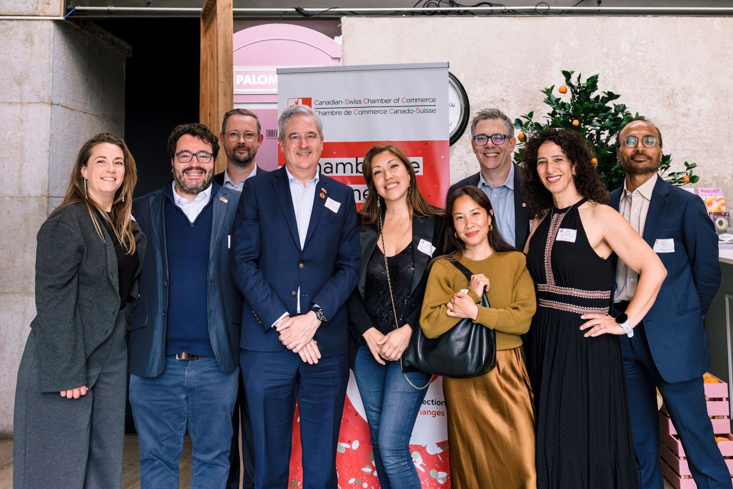Group of people standing in front of a Canadian-Swiss Chamber of Commerce banner with Jean-Paul Lemieux at the center.