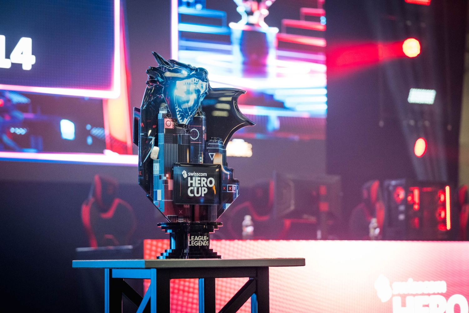 Swisscom Hero Cup esports trophy displayed on stage with colorful LED lighting at a gaming tournament event.