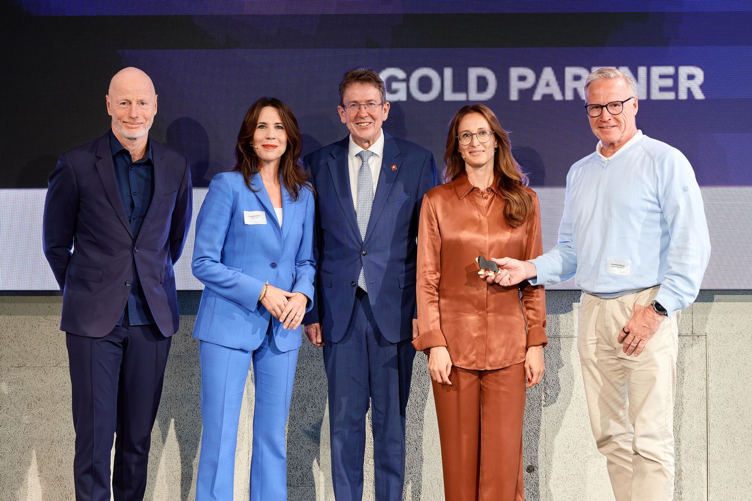 From left to right, Marc Walder, Susanne Wille, Albert Rösti, Franziska Barmettler, and Andreas Meyer stand together on a stage at an event.