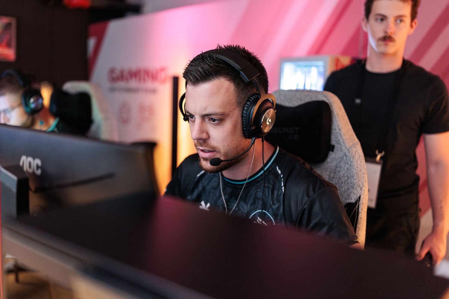 CSGO player ALX wearing a headset sits focused at a gaming monitor during the Ibex Spring Finals 2026 at Erupt.