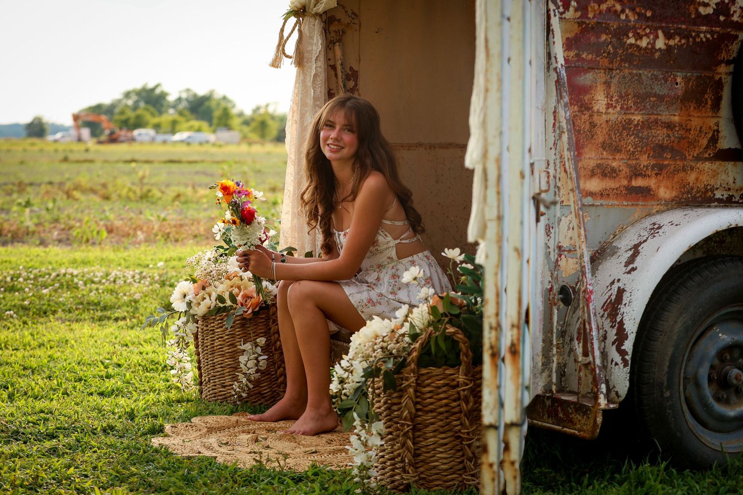 Senior portrait beside a vintage truck and flowers outdoors