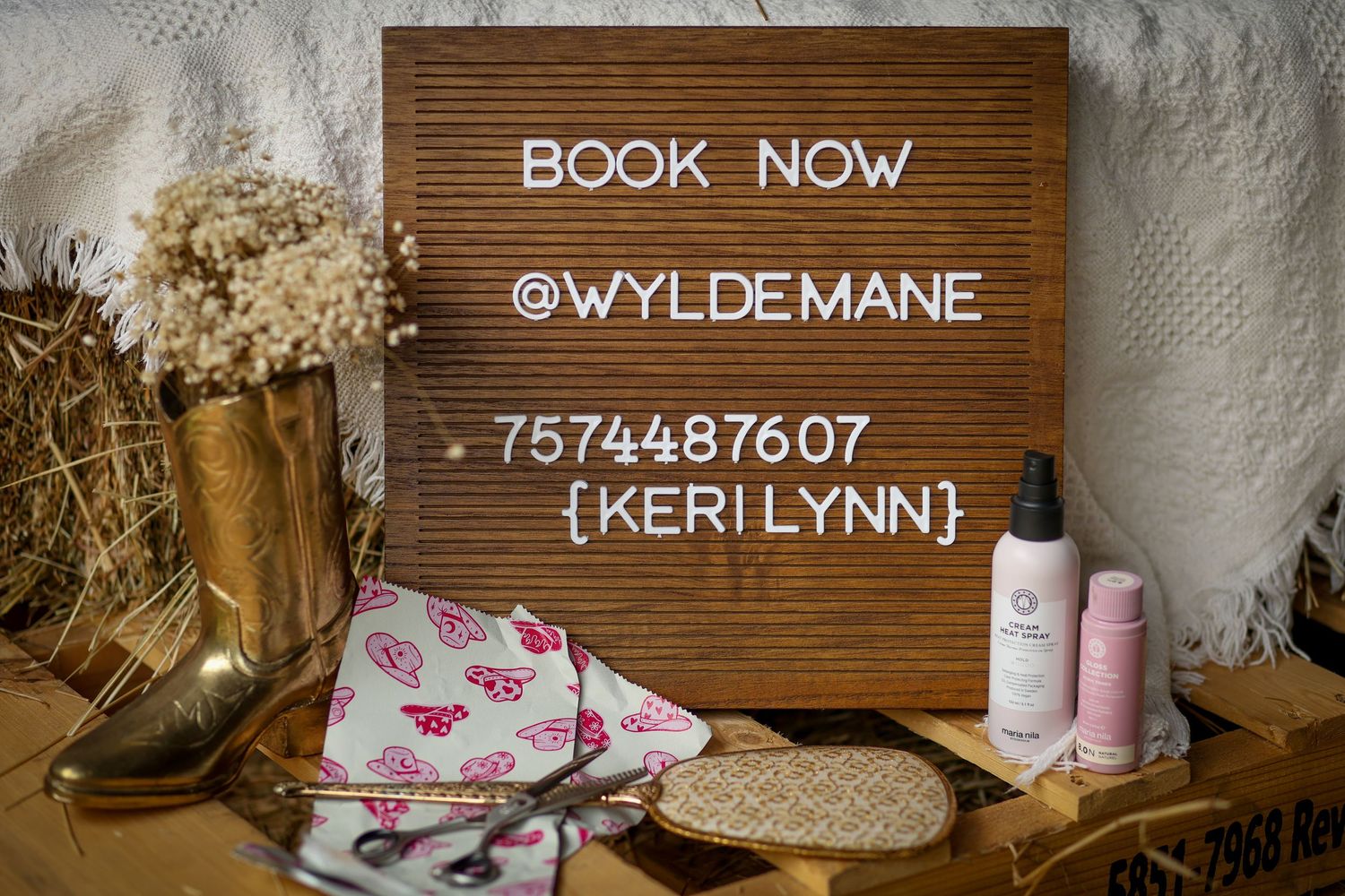 Branding detail photo with business sign, flowers, boots, and products