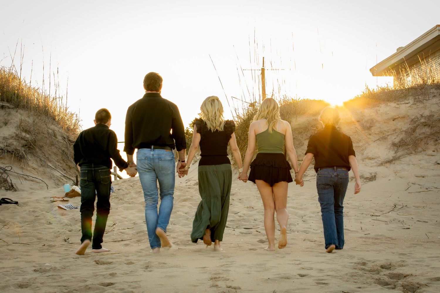 Family walking together on the beach at sunset