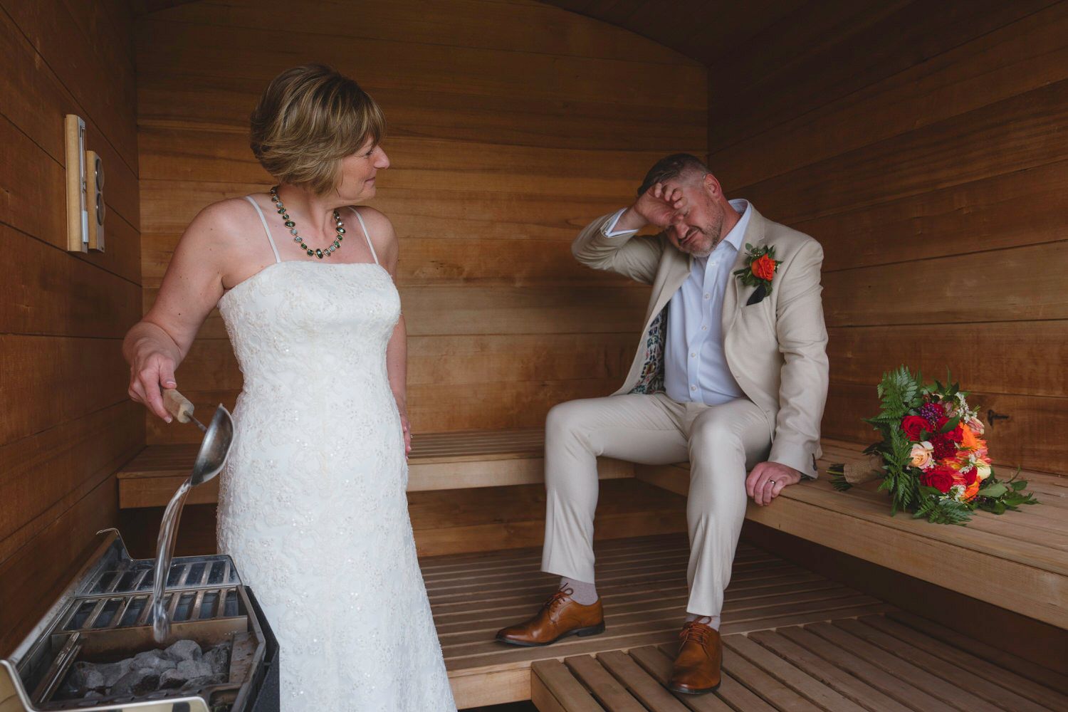 Bride and groom share an emotional first look moment inside a wooden sauna on their wedding day.