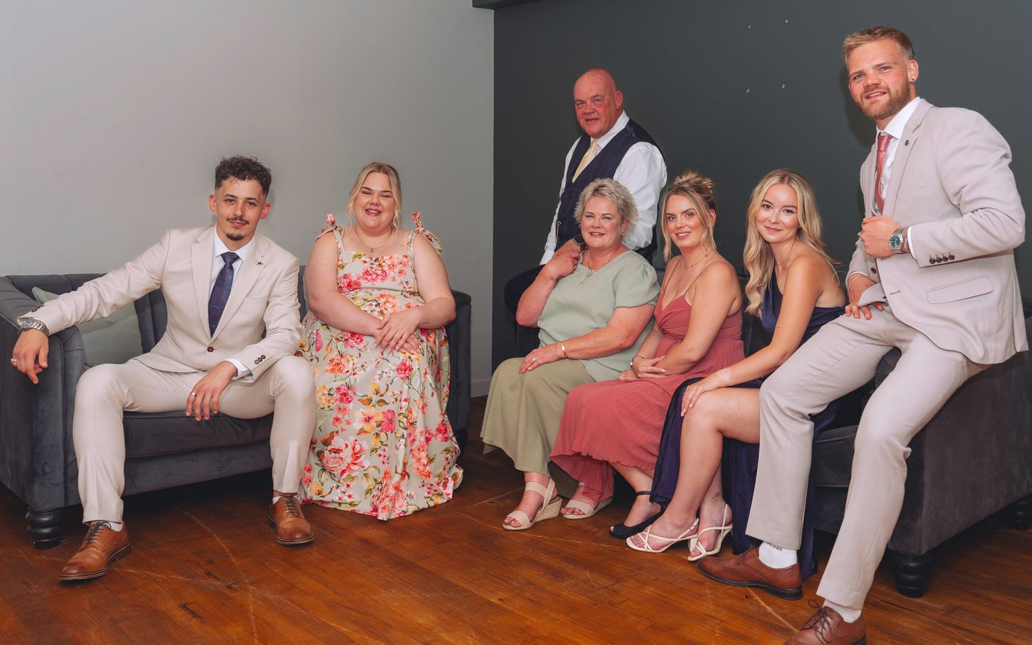 Family group of seven adults posing together for a formal photo, dressed in elegant attire for a special occasion.