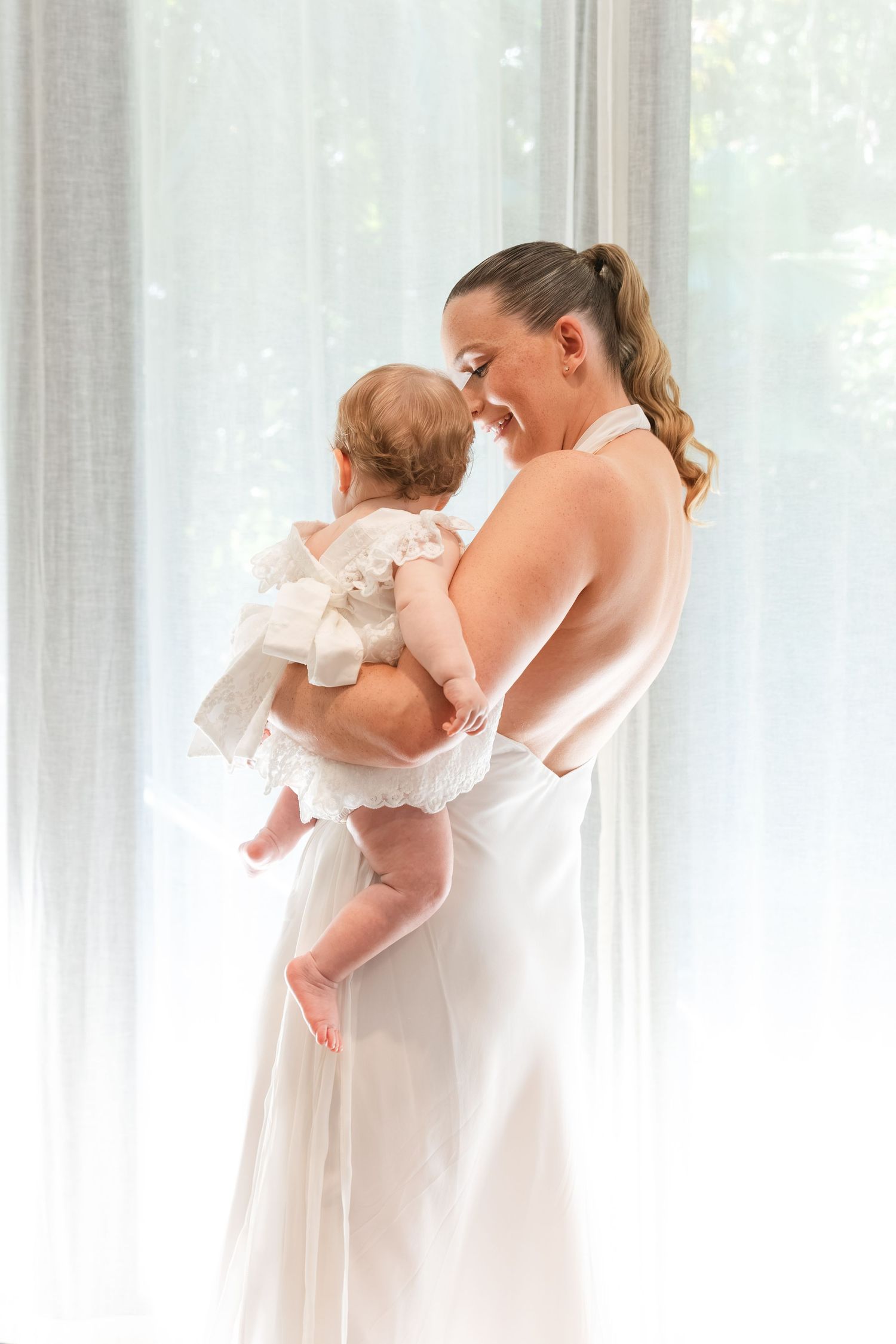 Happy bride holding her baby during her Fiji wedding day