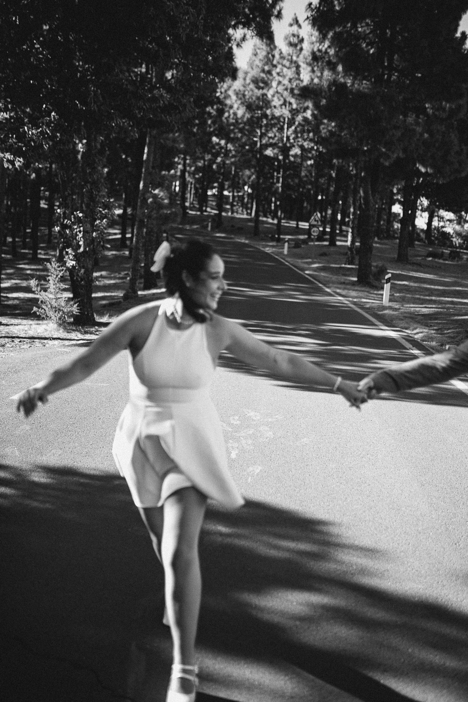 A person in white spins gracefully on a paved outdoor path.