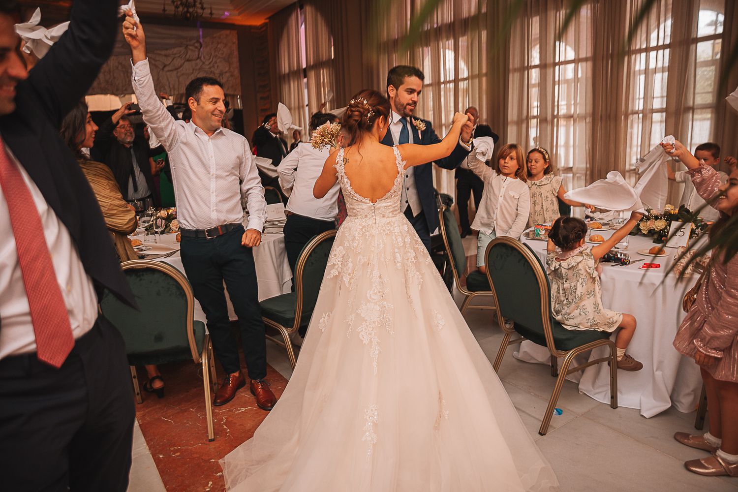 Wedding celebration with guests dancing and enjoying festivities in an elegant venue.