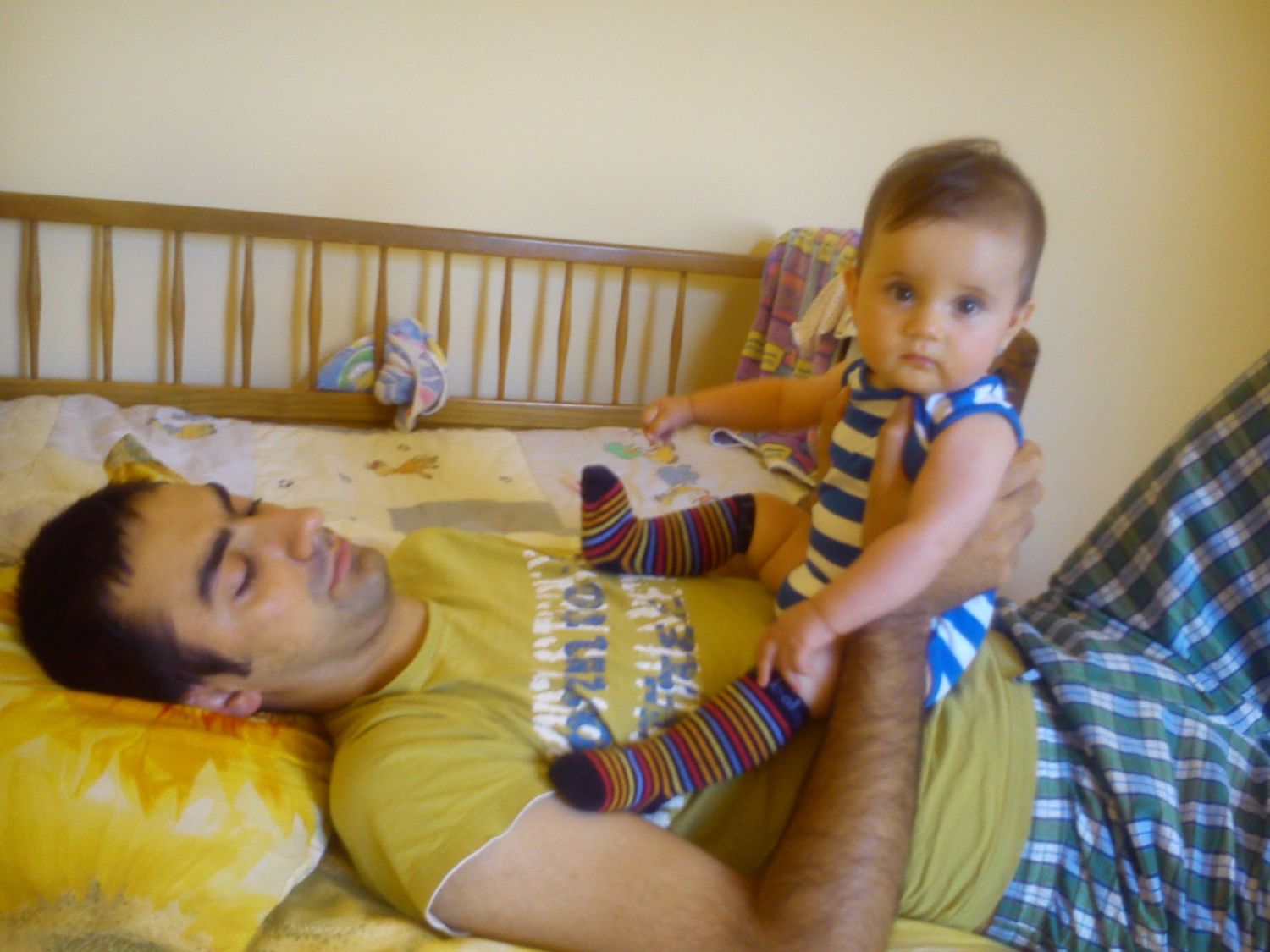 Playful moments captured on a yellow bed or couch showing interaction with a small child.