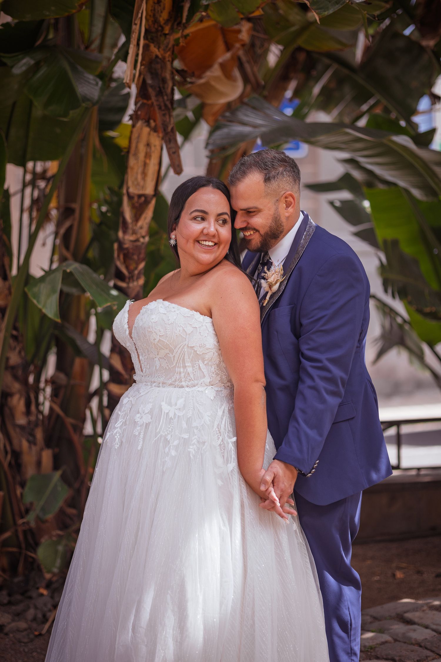 Intimate wedding portraits captured among tropical plants and natural greenery.