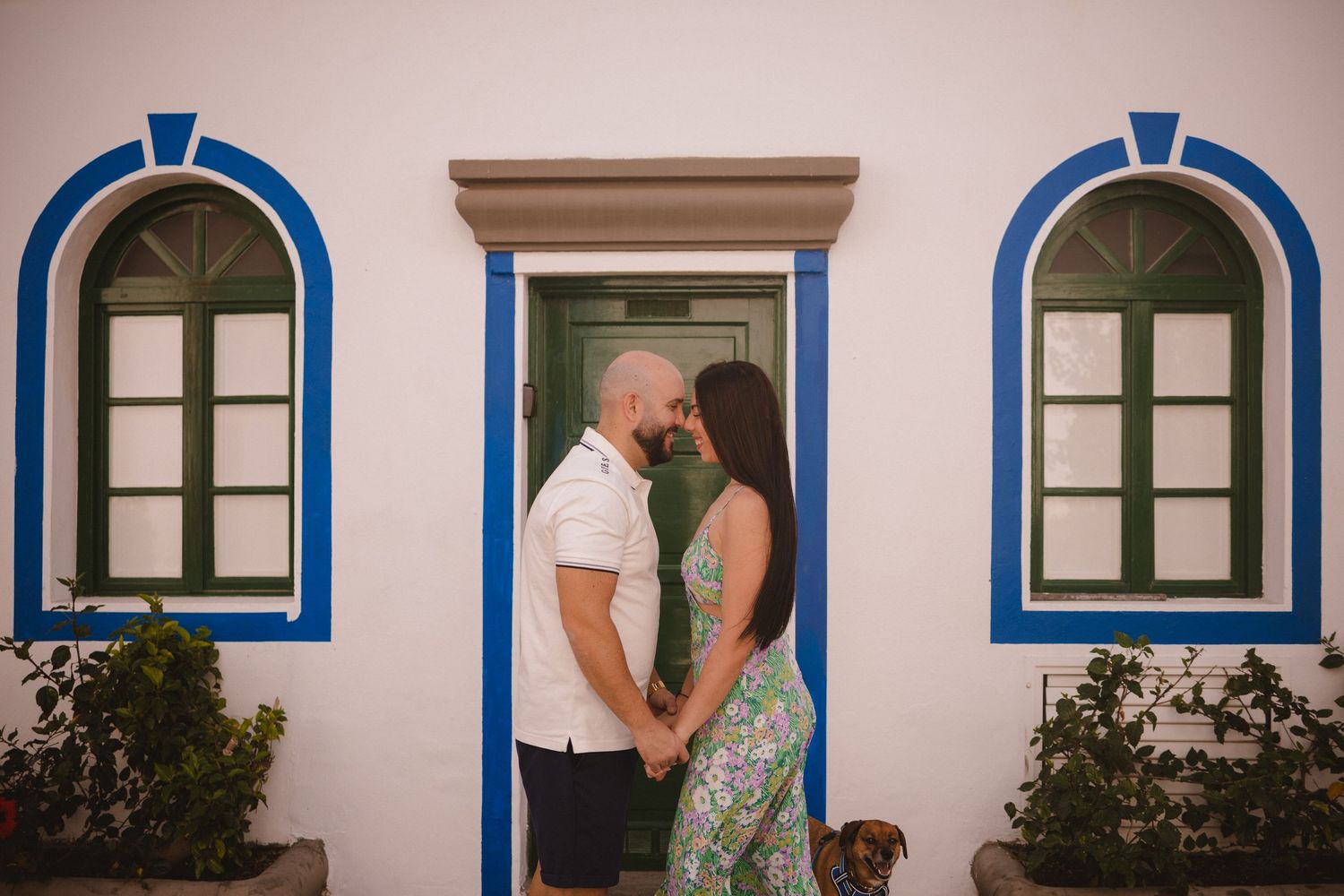 White building with blue-trimmed windows and arches creating Mediterranean architectural style.
