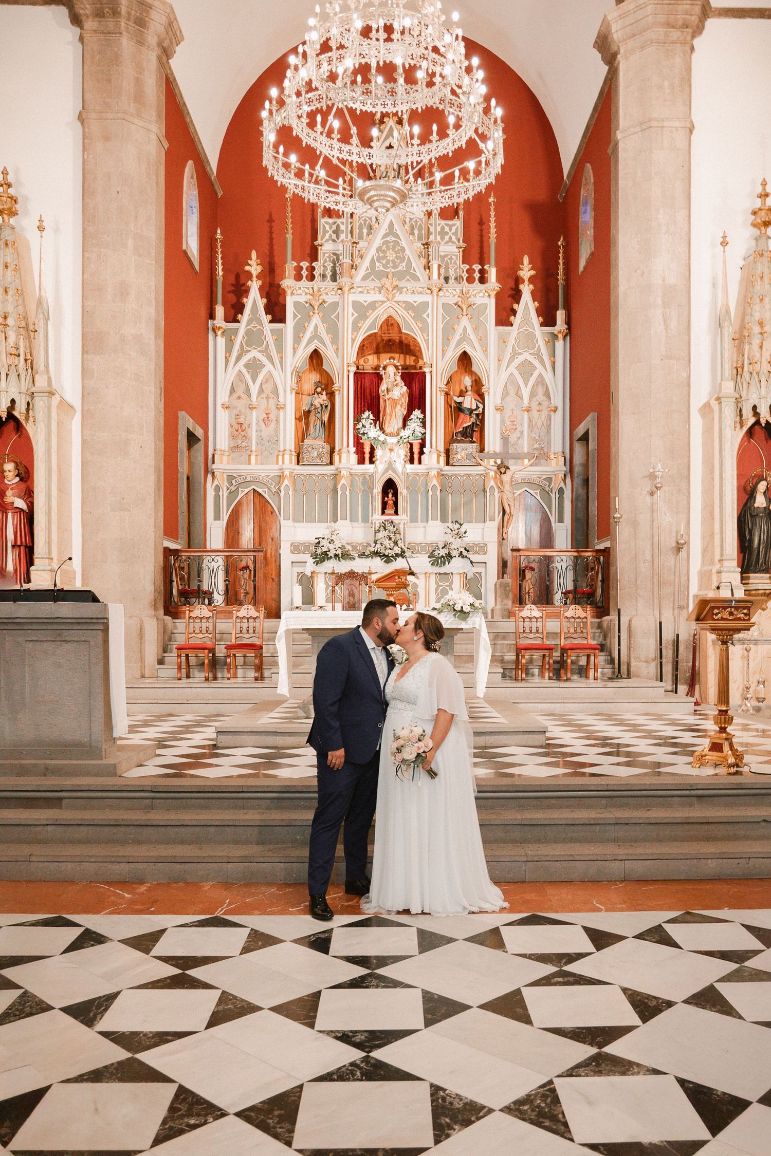 Elegant church interior with gothic architecture and black and white checkered marble floors.